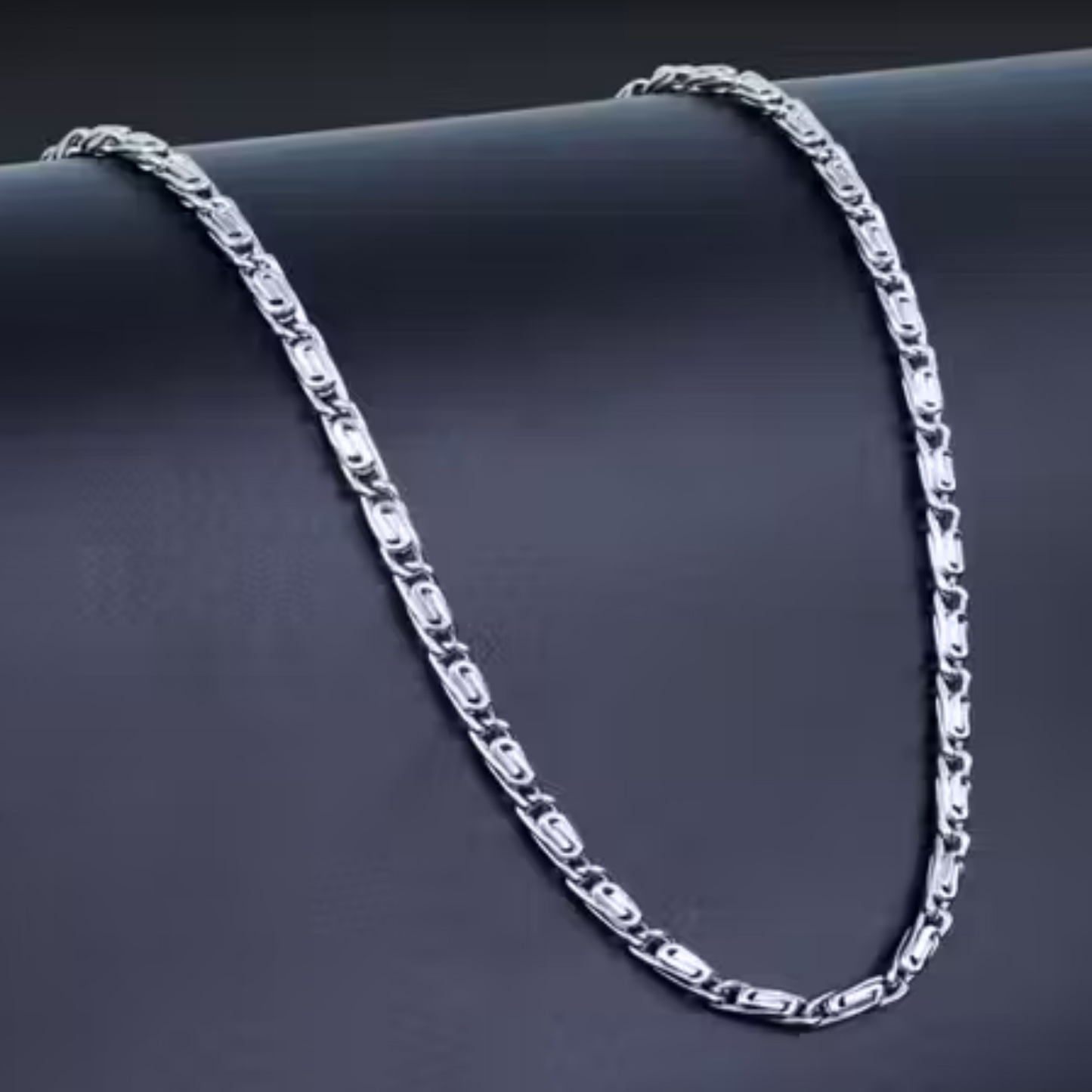 Silver chain necklace on a dark surface