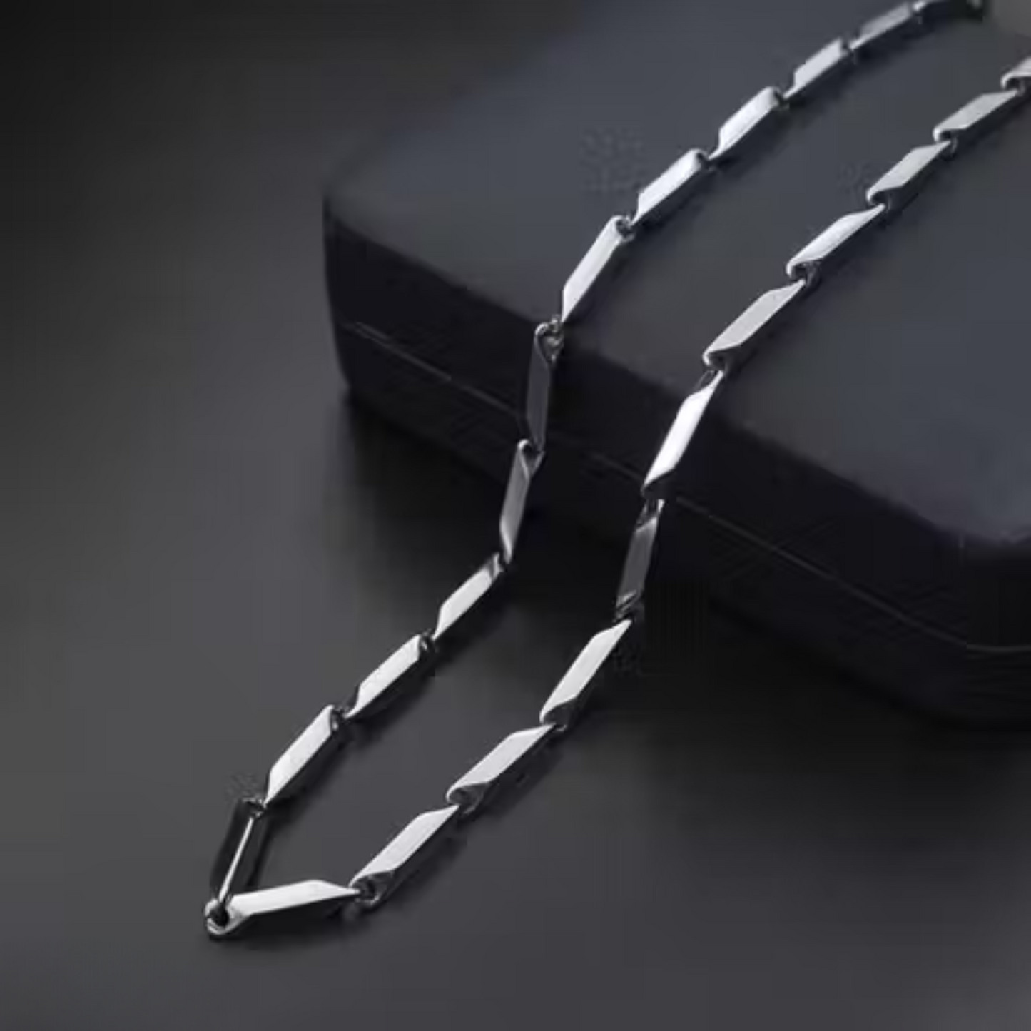 Silver chain necklace on a black surface