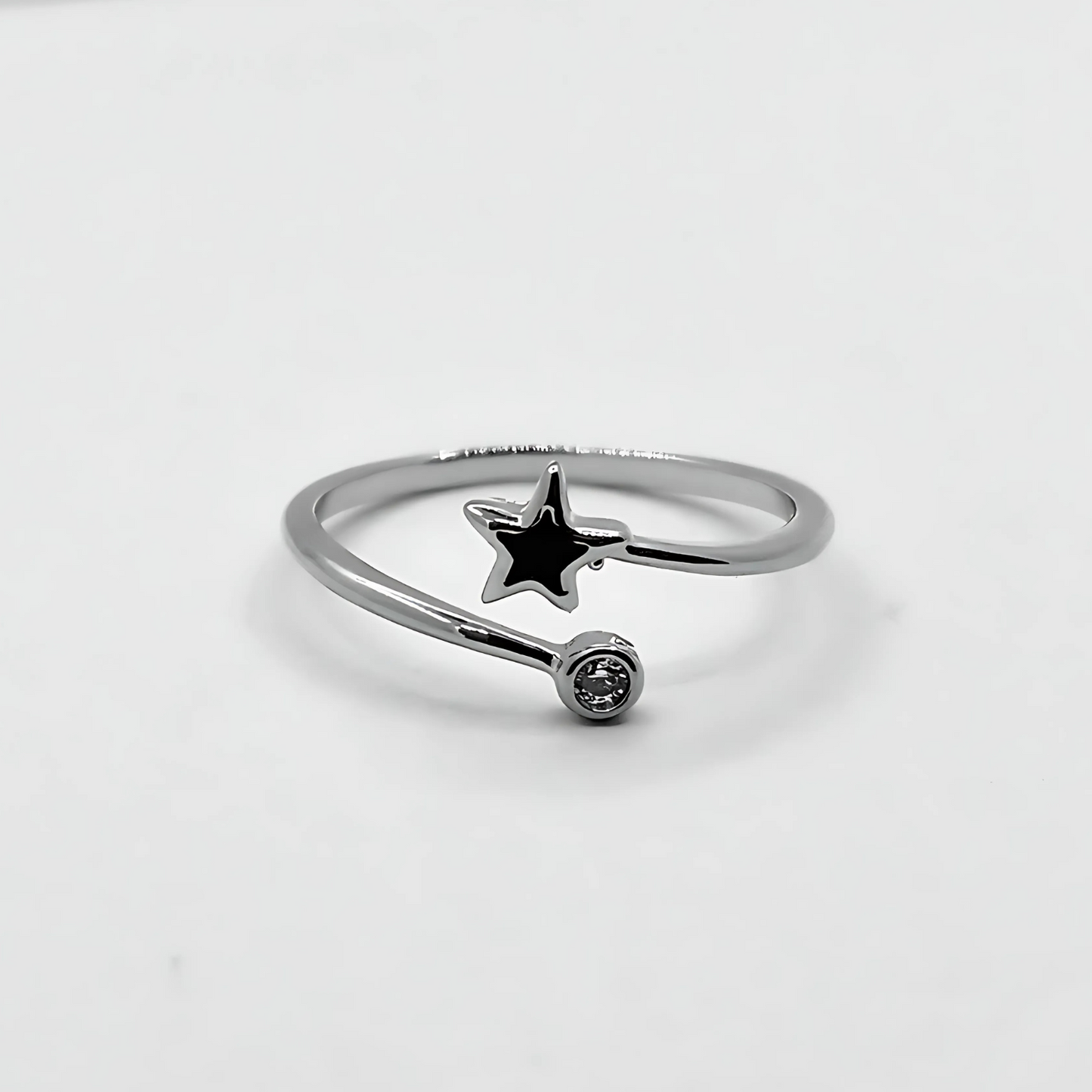 Silver ring with a star-shaped pendant on a light gray background