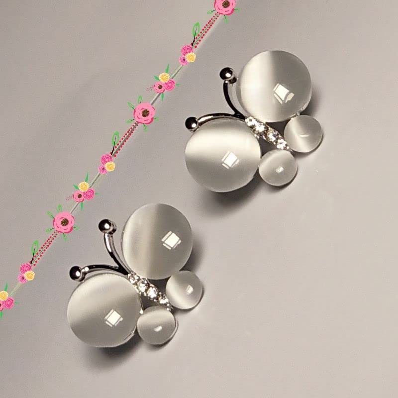 Butterfly-shaped jewelry with floral elements on a gray background
