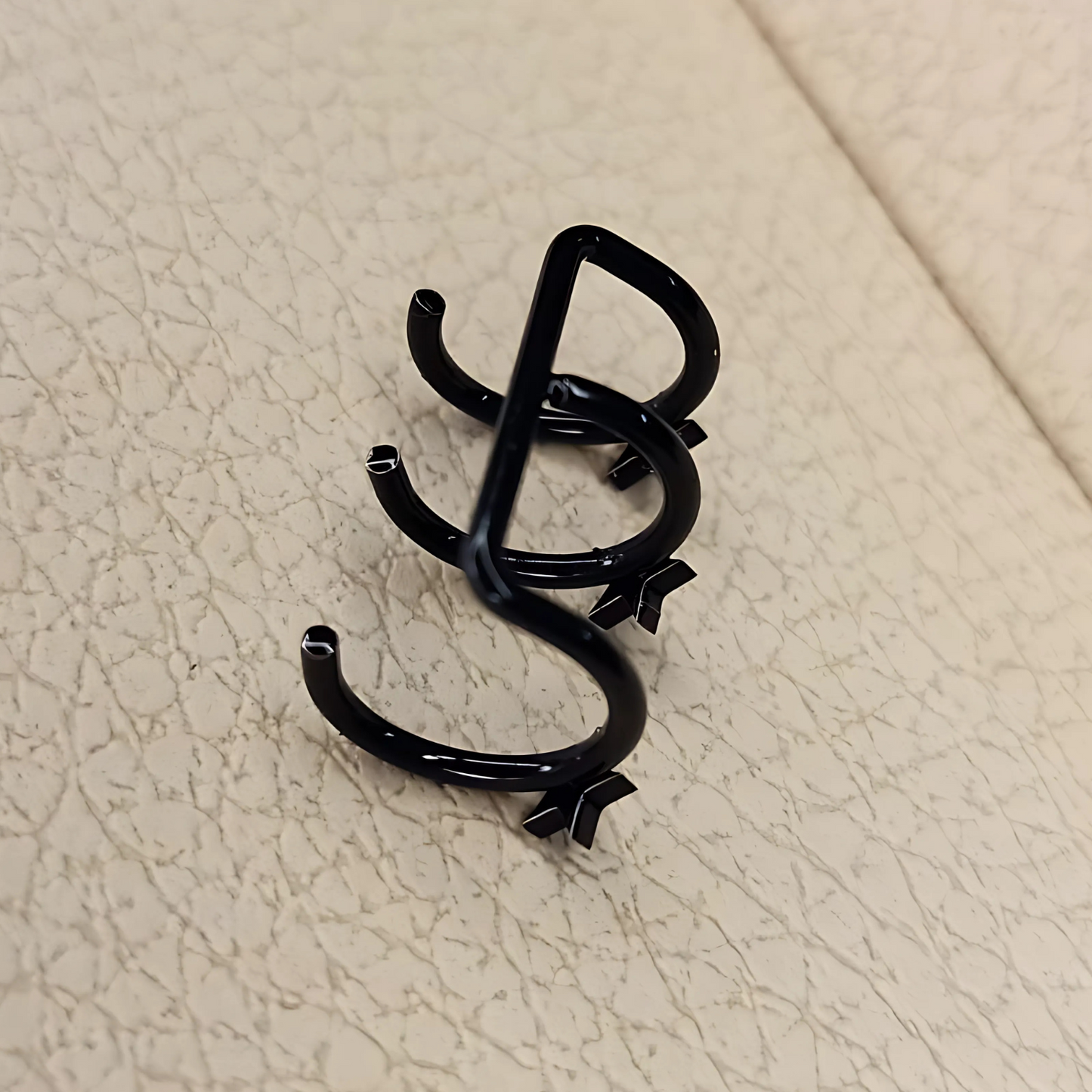 Black metal clip on a beige textured surface