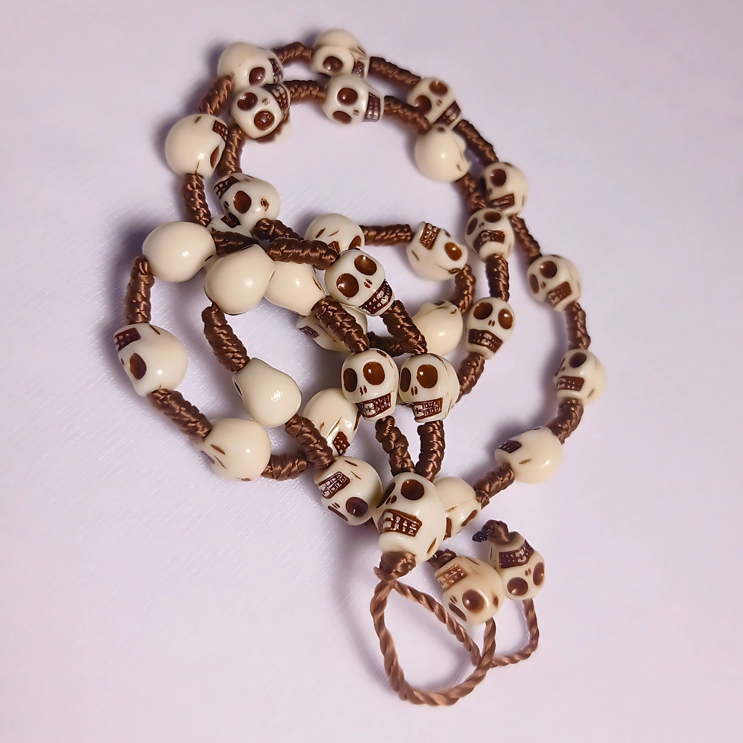 Necklace with skull-shaped beads on a light purple background