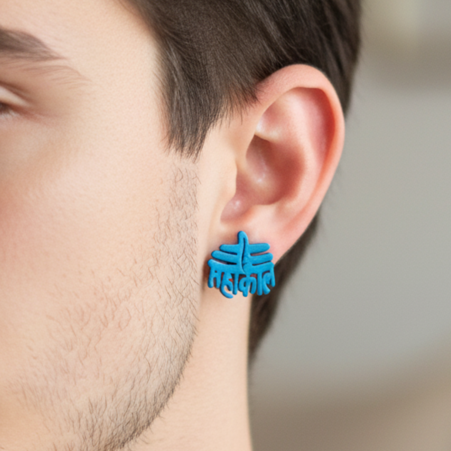 Blue earrings worn by a person with a blurred background
