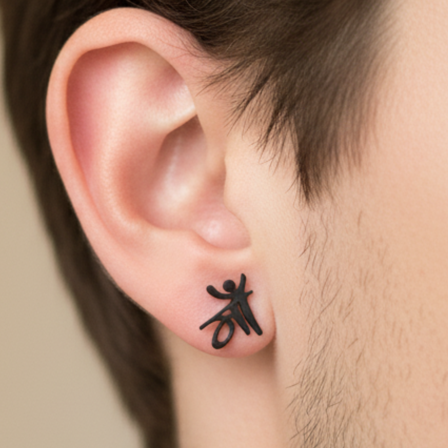 Black ear cuff worn on an ear with a neutral background