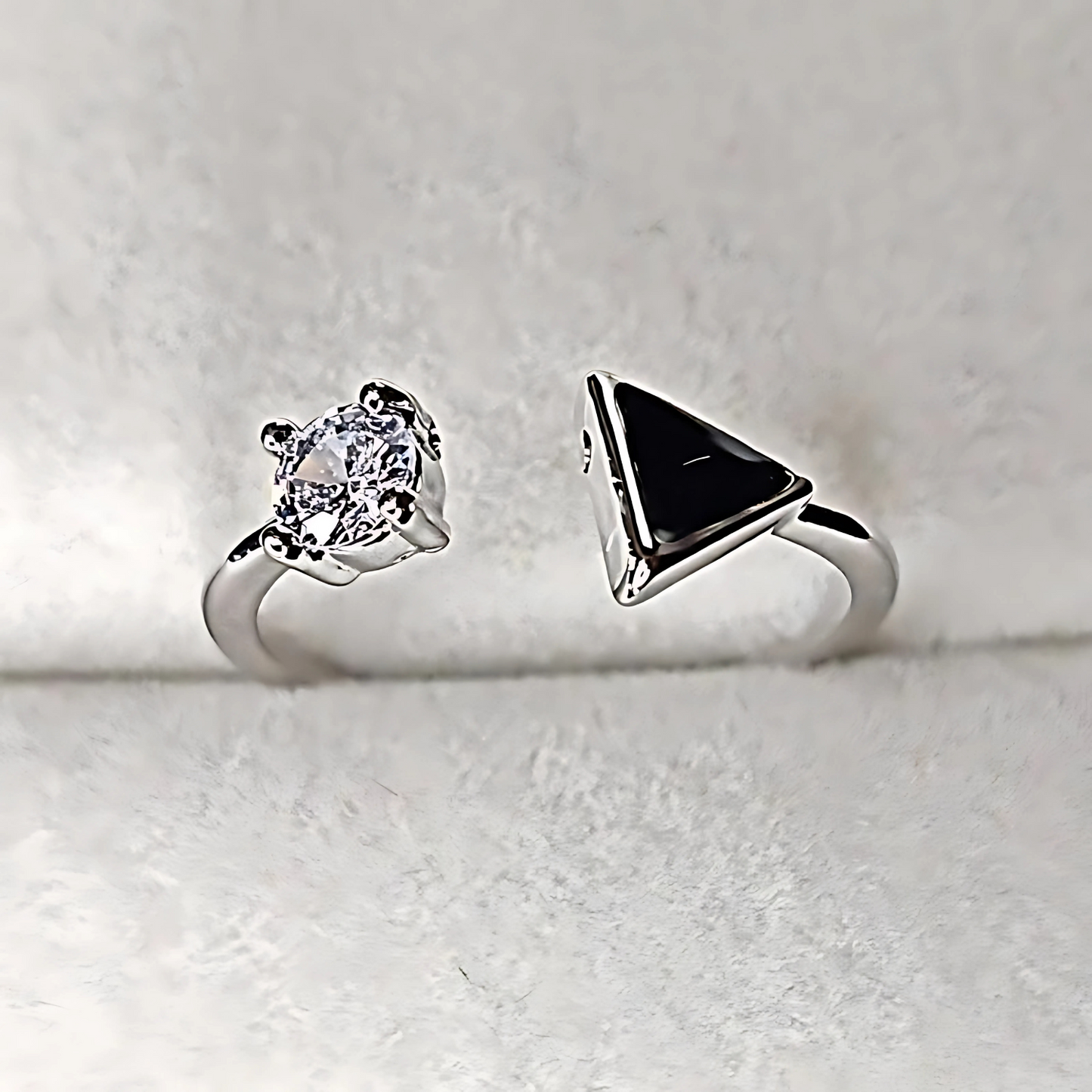 Two silver rings with gemstones on a light gray background