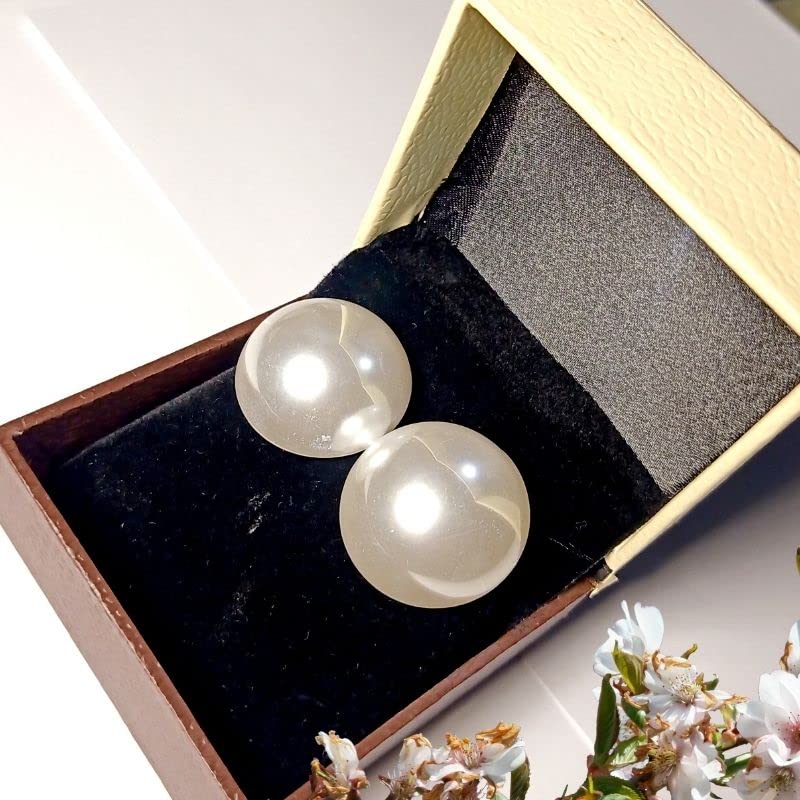 Pearl earrings in a jewelry box with flowers in the background