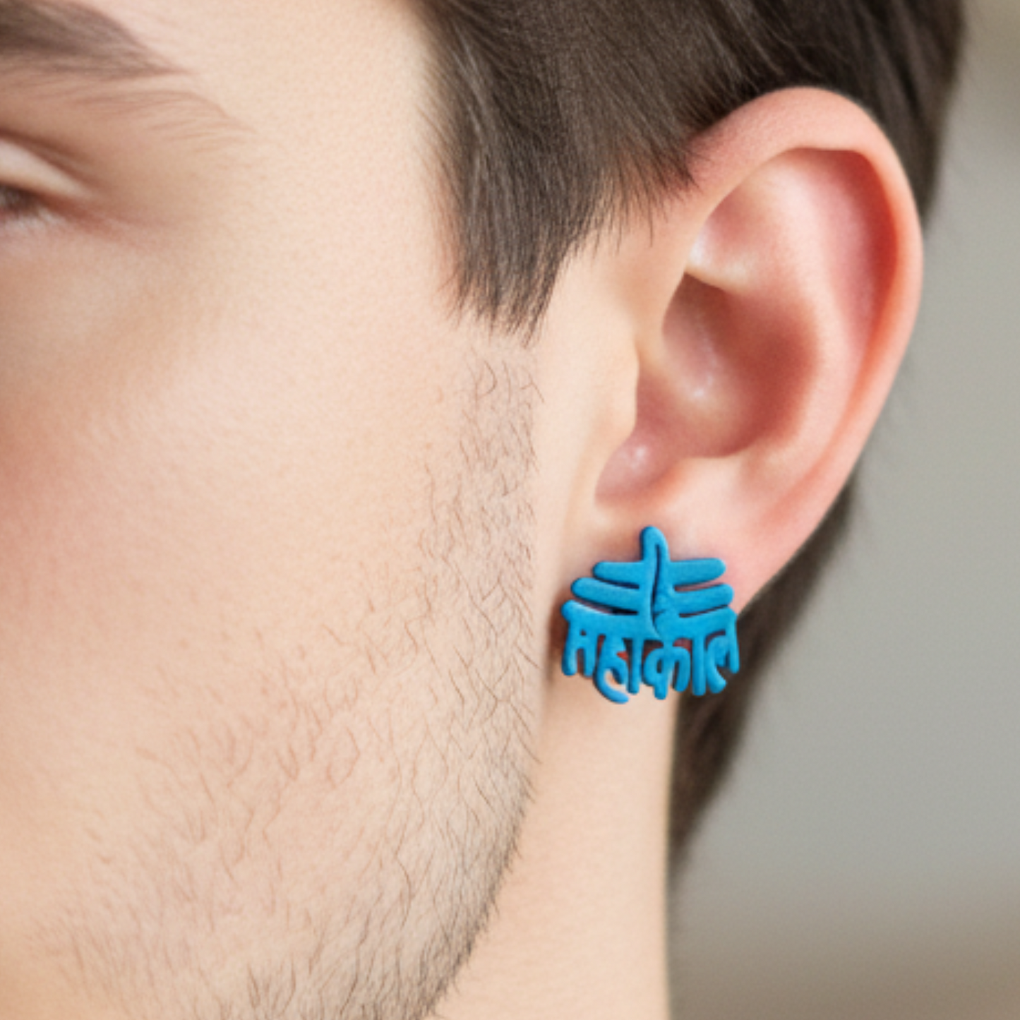 Blue earrings worn by a person with a neutral background