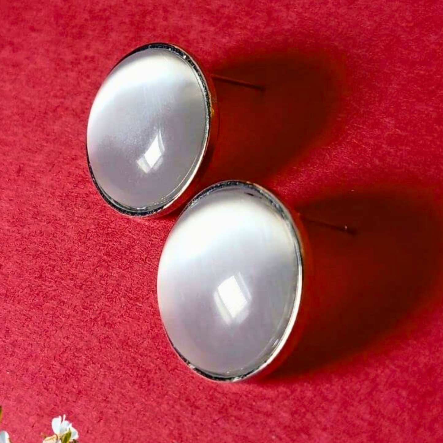 Round earrings with a gold rim on a red background