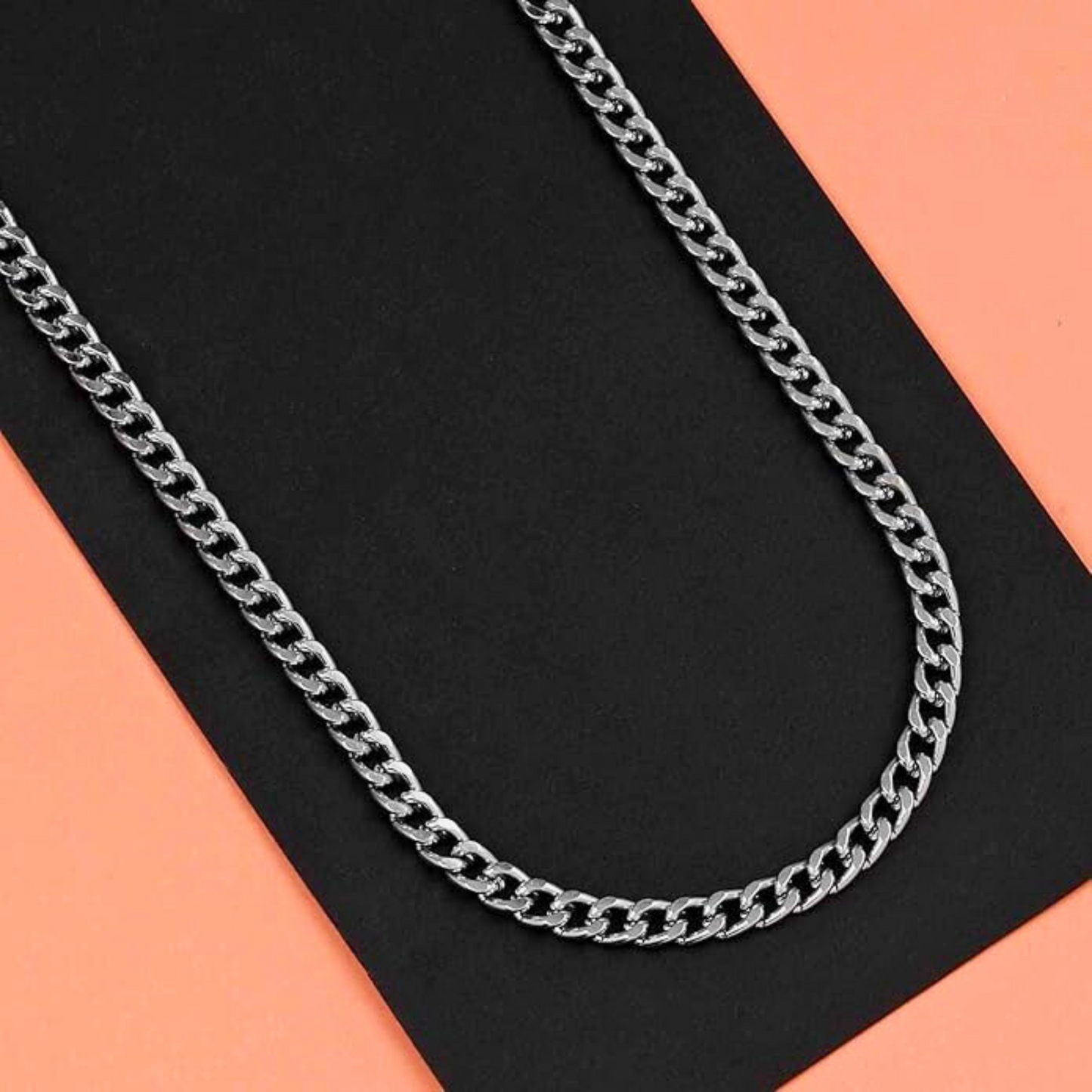Silver chain necklace on a black and orange background