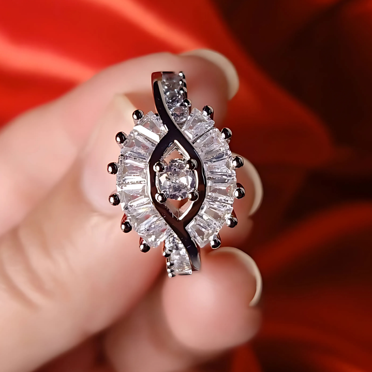Diamond ring held between fingers against a red background