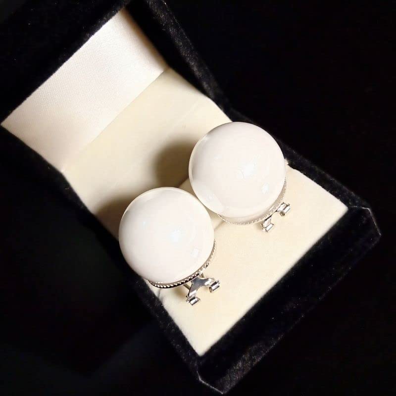 Pair of white round earrings with silver hooks in a black jewelry box.