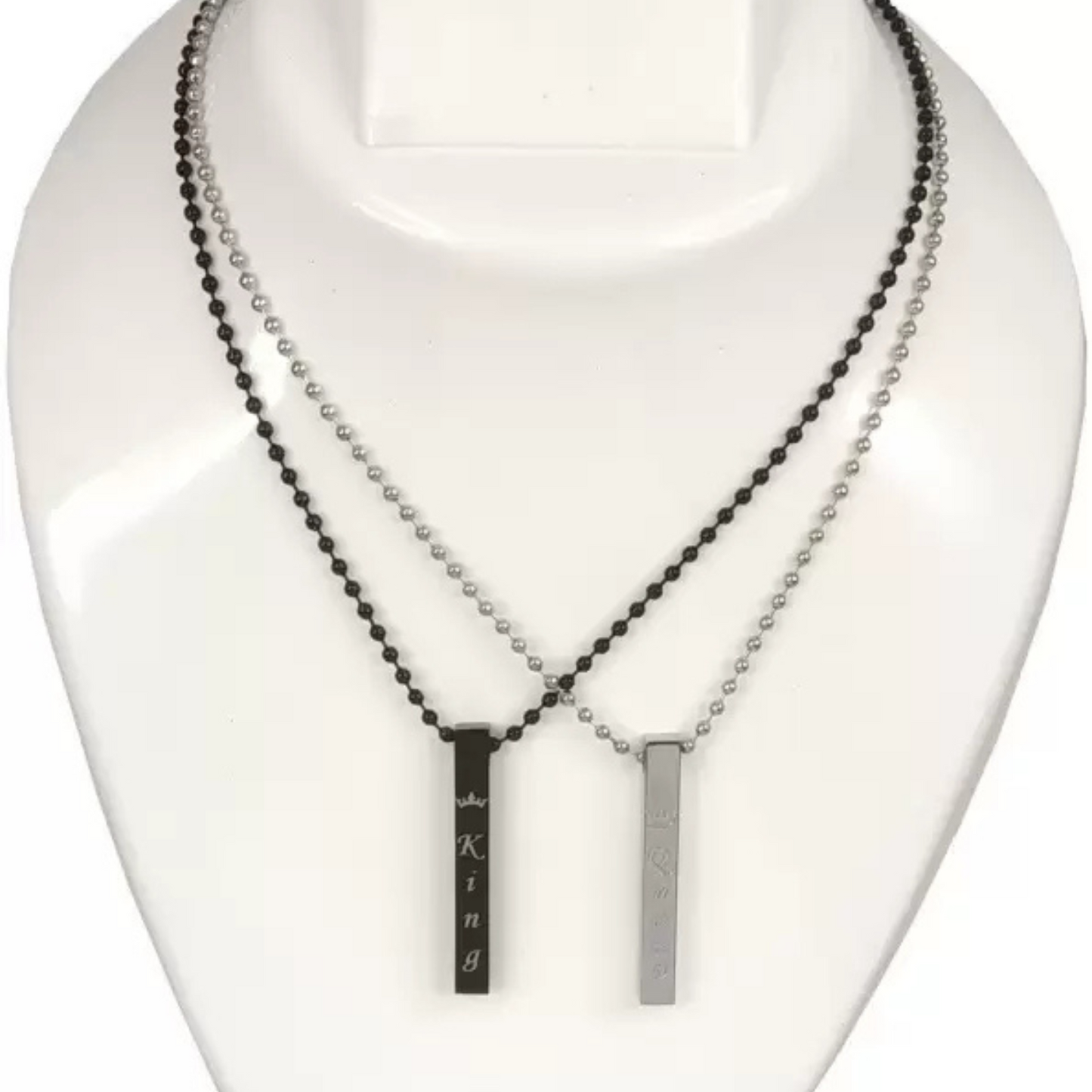 Two necklaces on a mannequin bust, one with black beads and the other with a silver bar pendant.