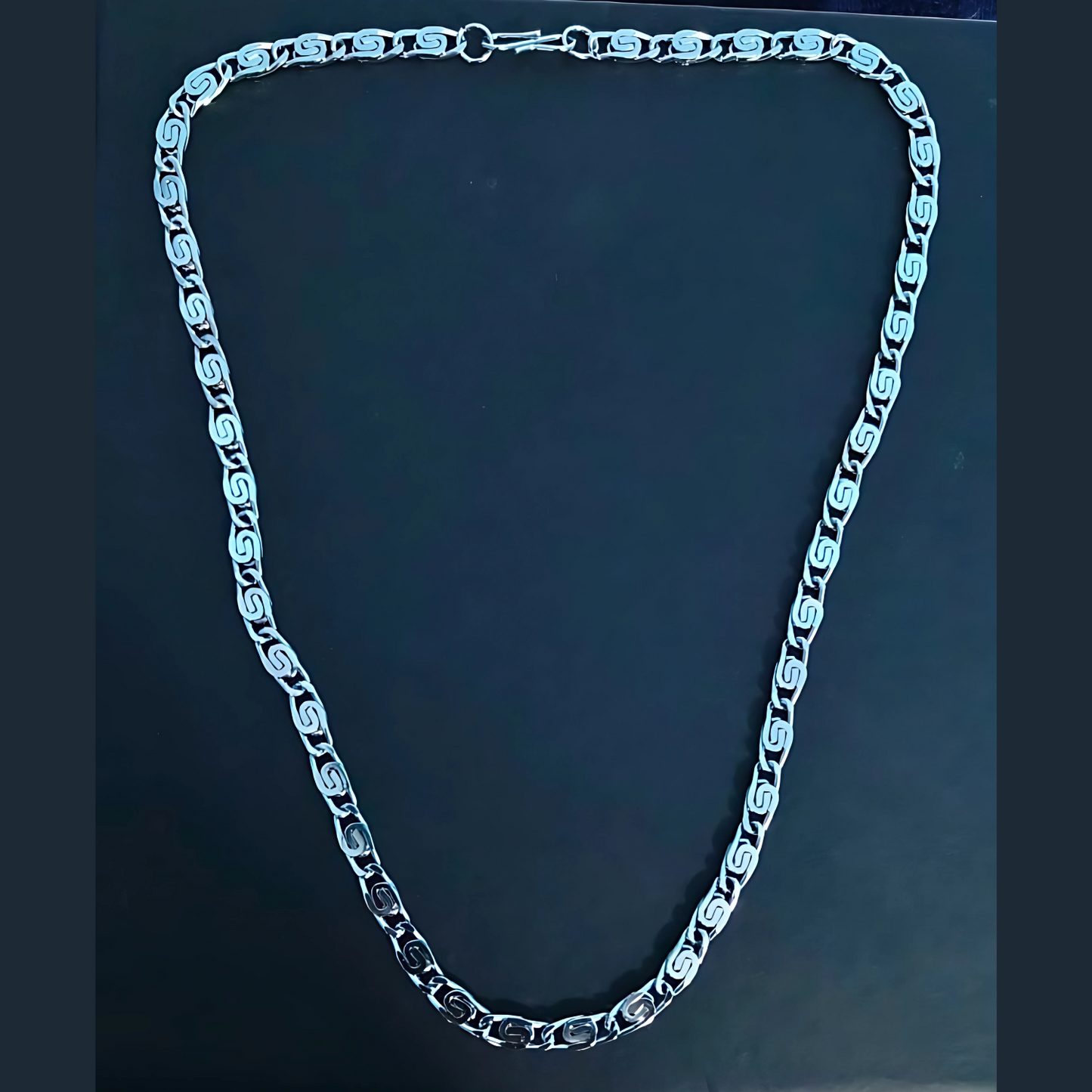 Silver chain necklace on a dark background