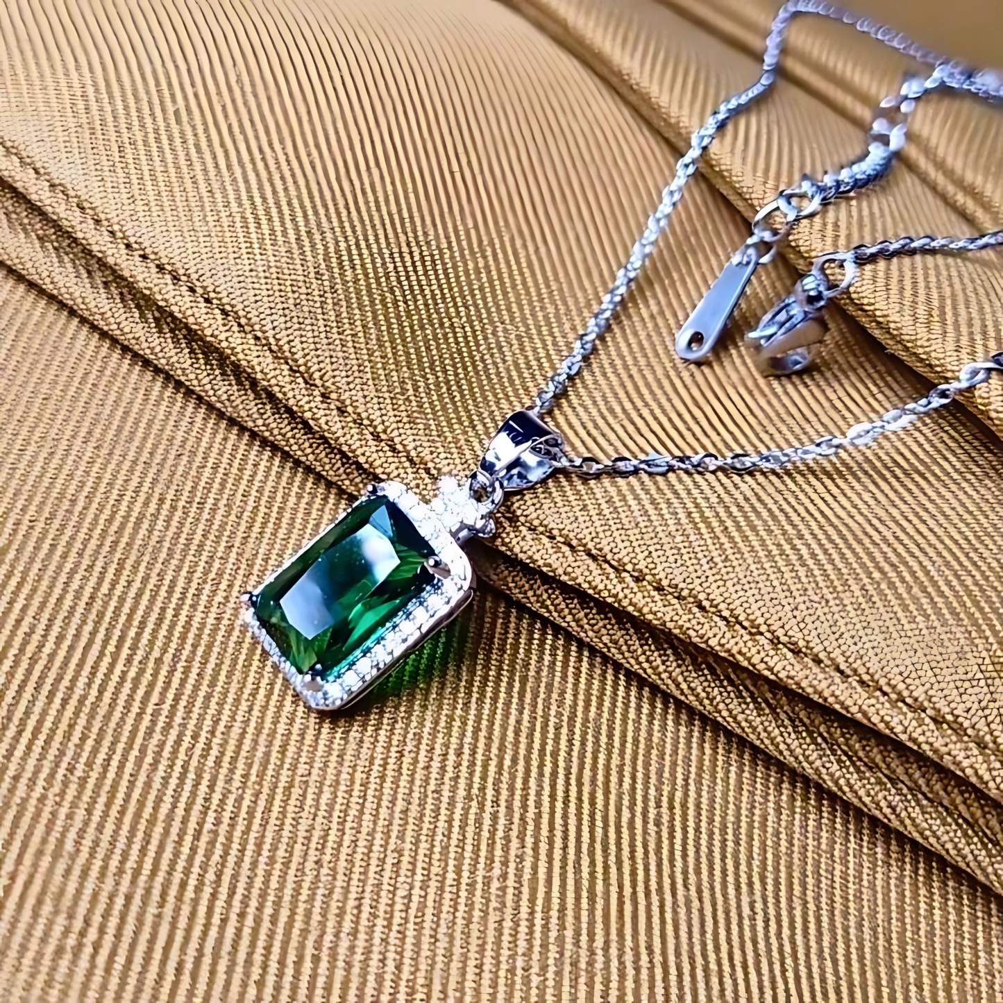 Necklace with a green gemstone pendant on a brown fabric background
