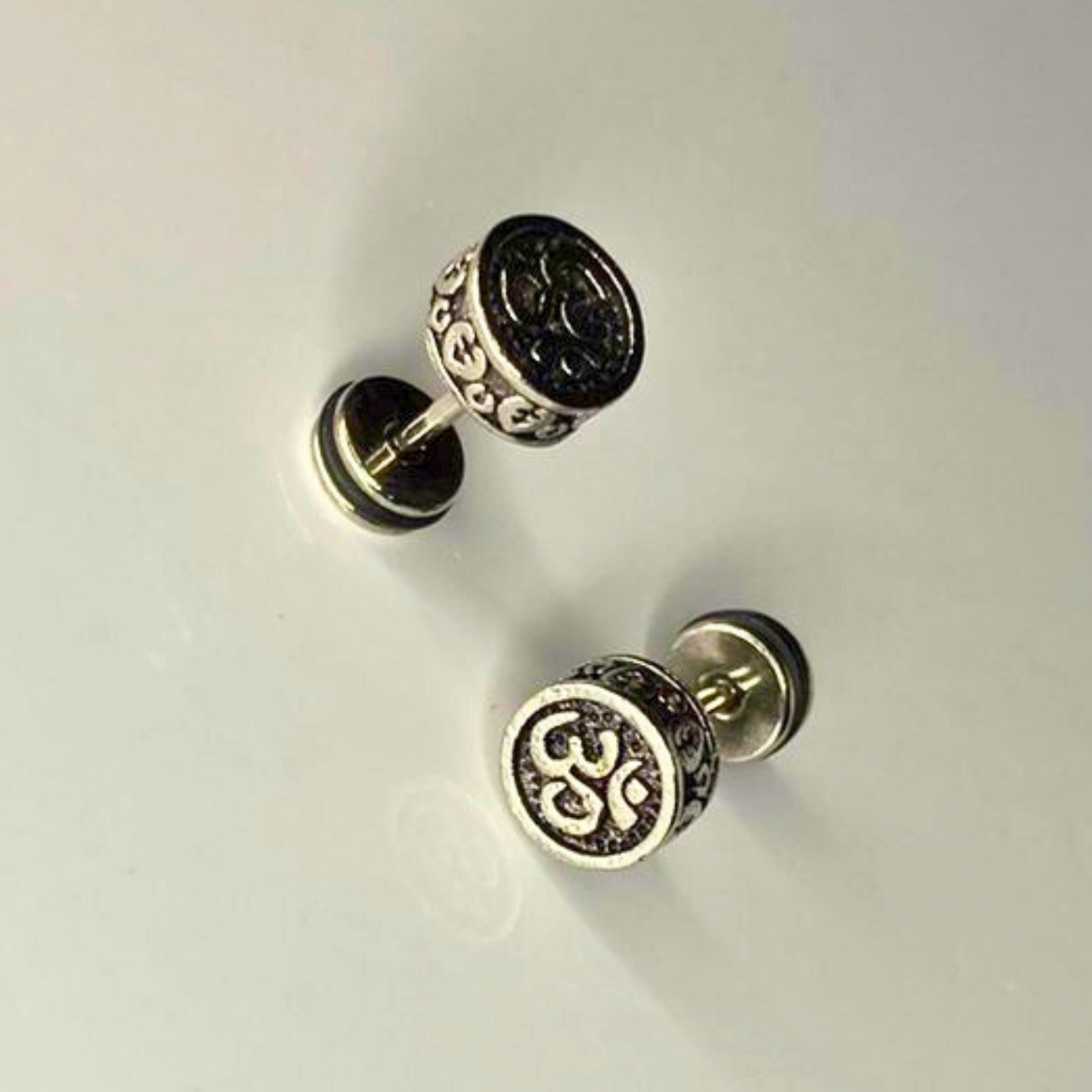 Pair of silver earrings on a light gray background