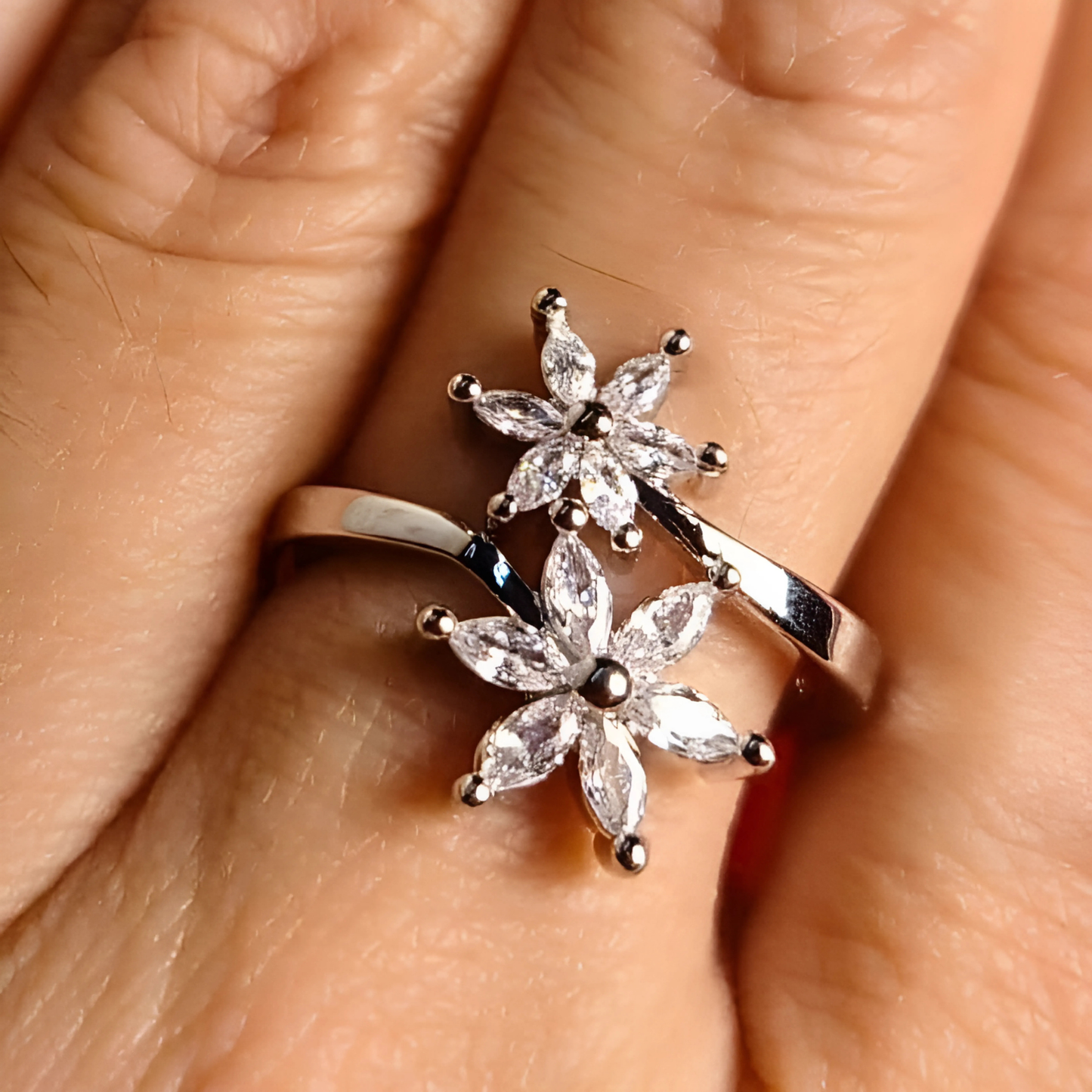 Silver floral ring on a person's finger