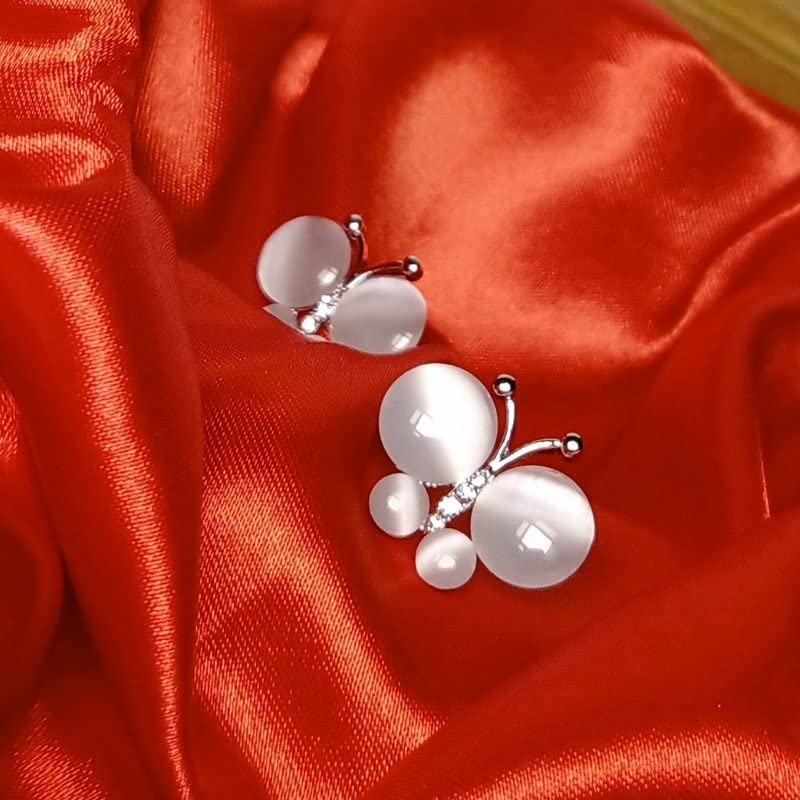 Pearl-like earrings on a red satin background