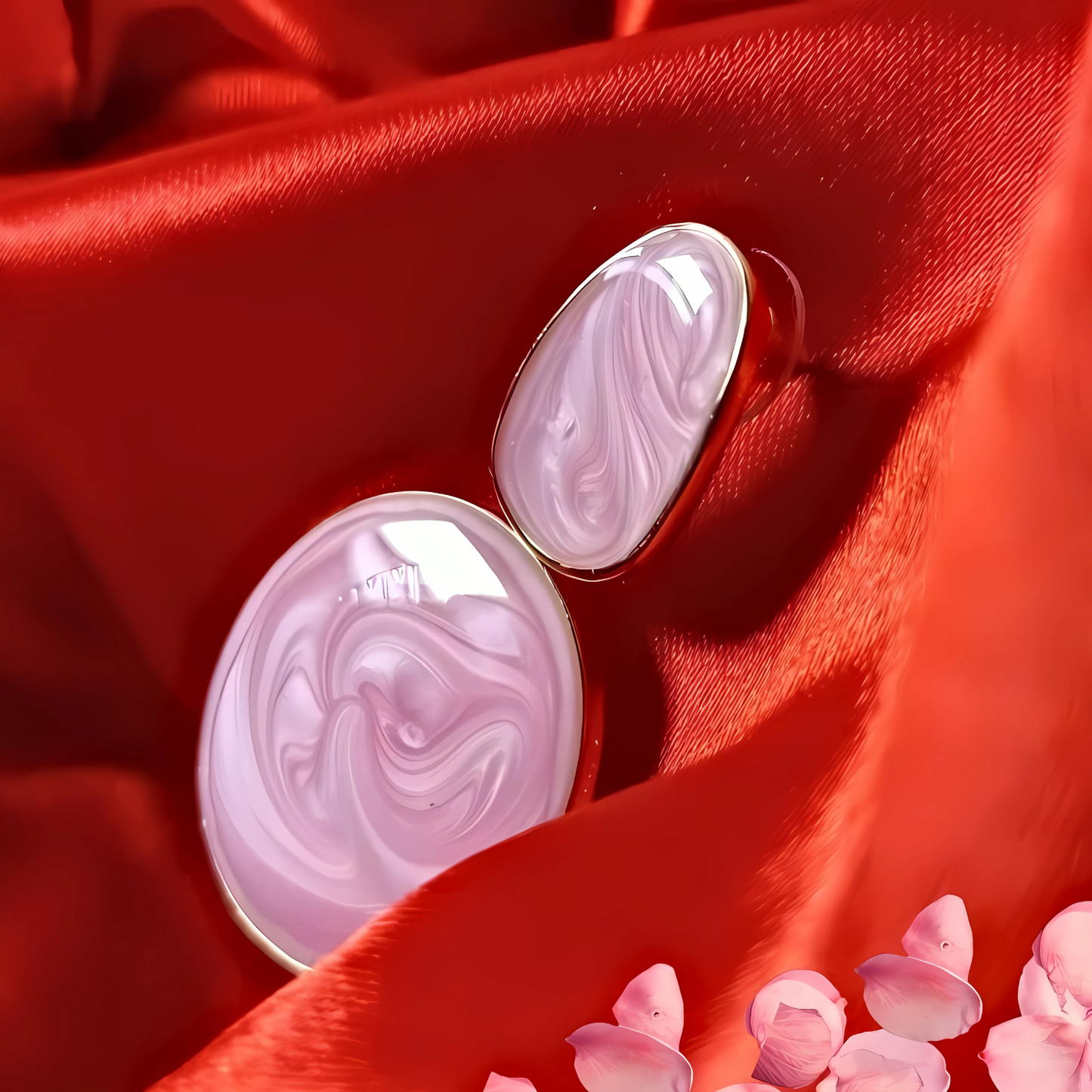 Pink marbled earrings on a red fabric background with pink flowers.