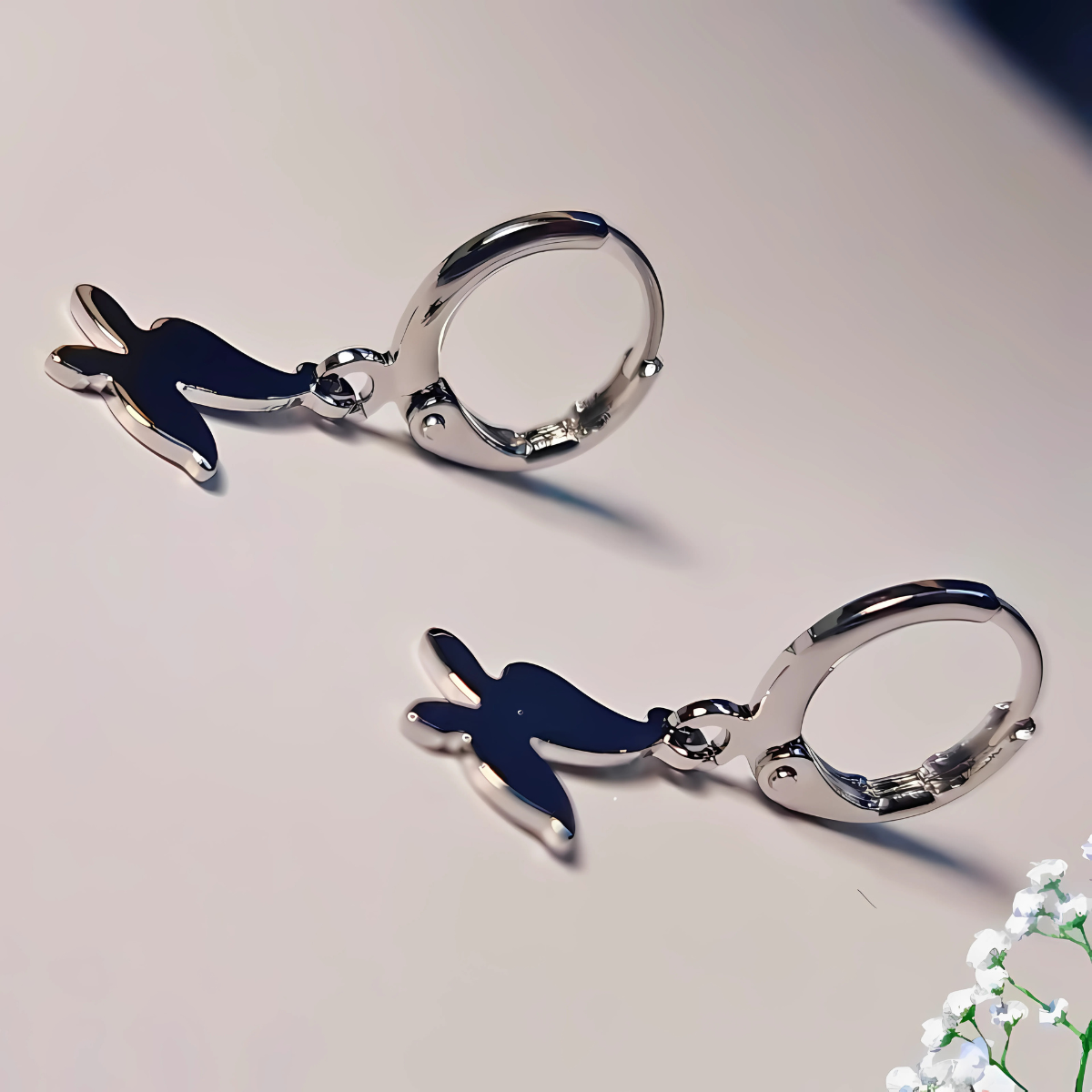 Pair of silver handcuff keychains with blue bird charms on a light gray background.