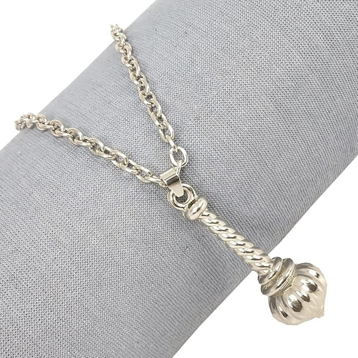 Silver necklace with a decorative pendant on a gray fabric background