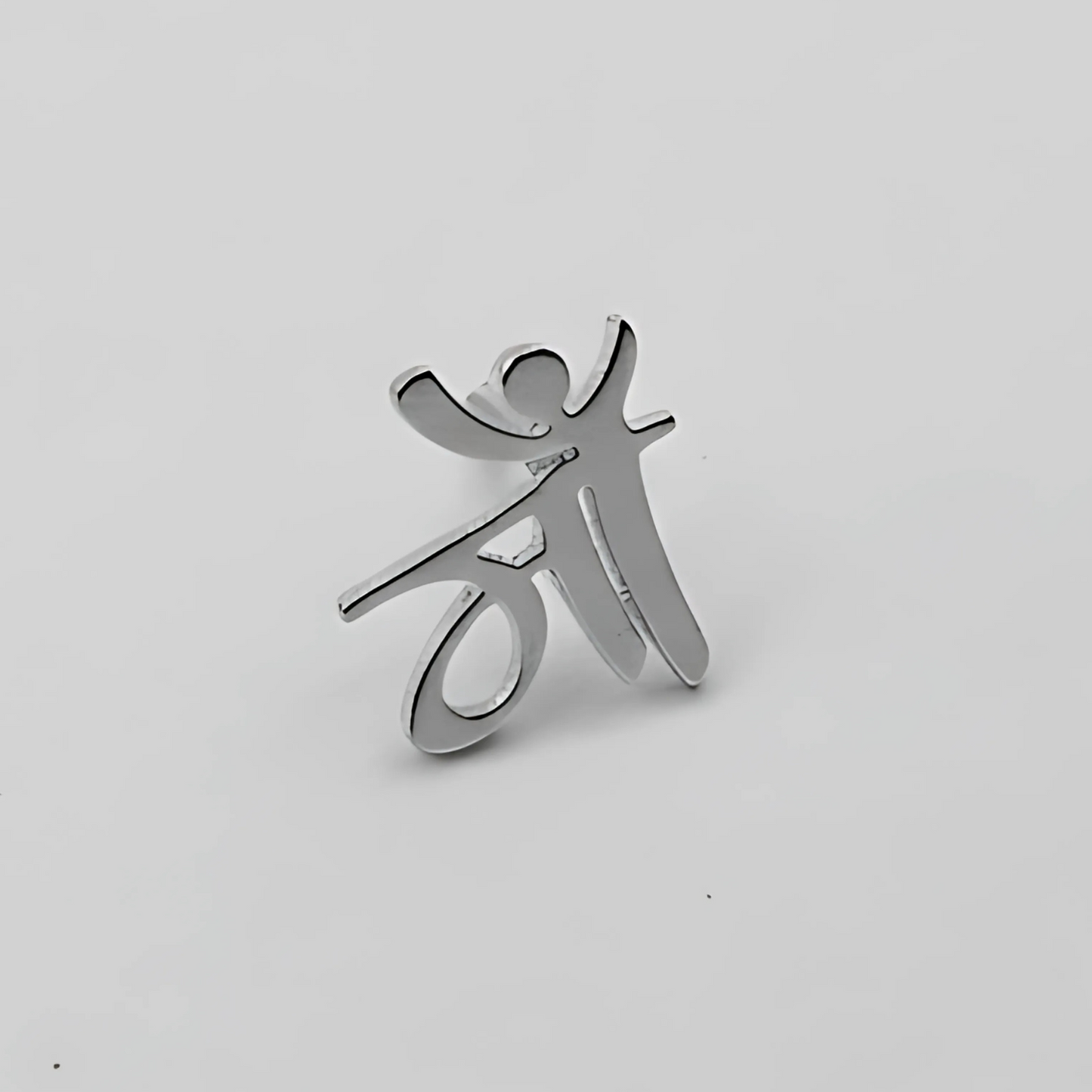 Silver pendant shaped like a stylized person on a light gray background