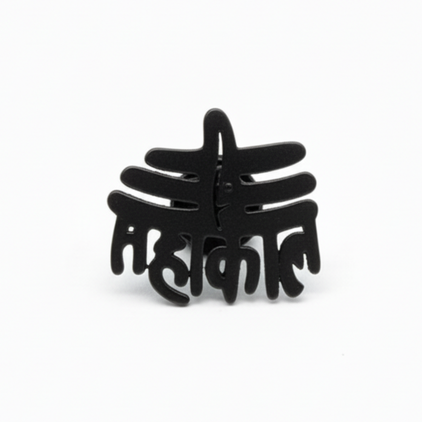 Black decorative item with intricate design on a white background