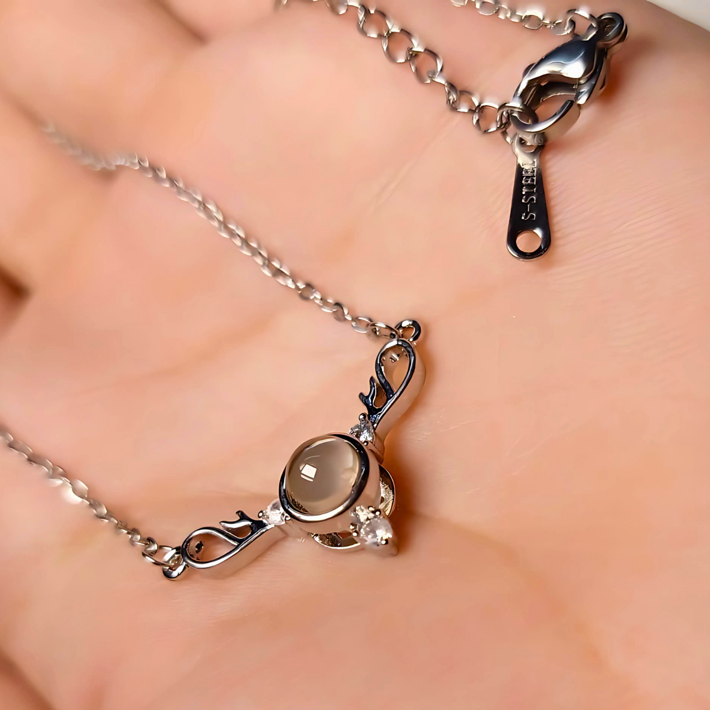 Silver necklace with a pendant on a hand