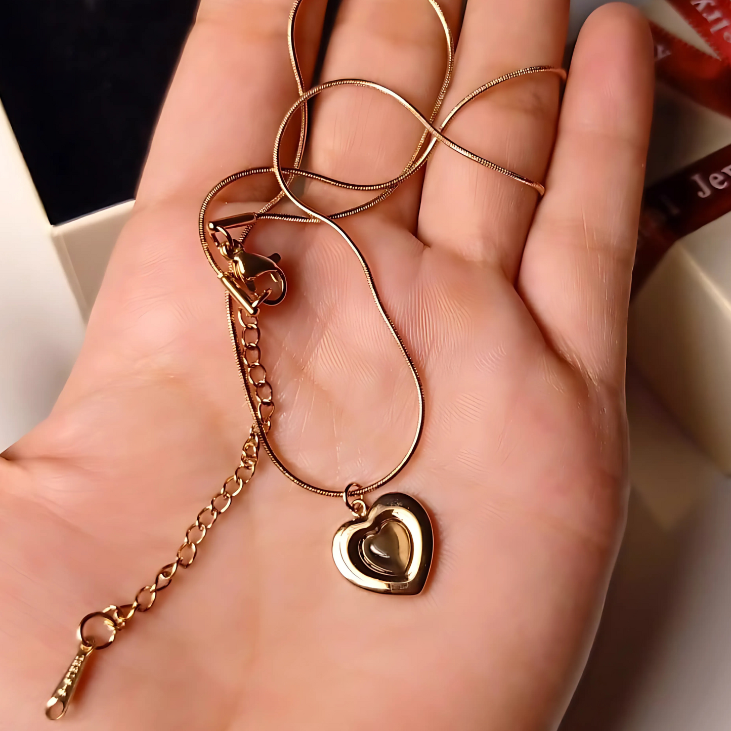 Gold heart-shaped pendant necklace on a hand