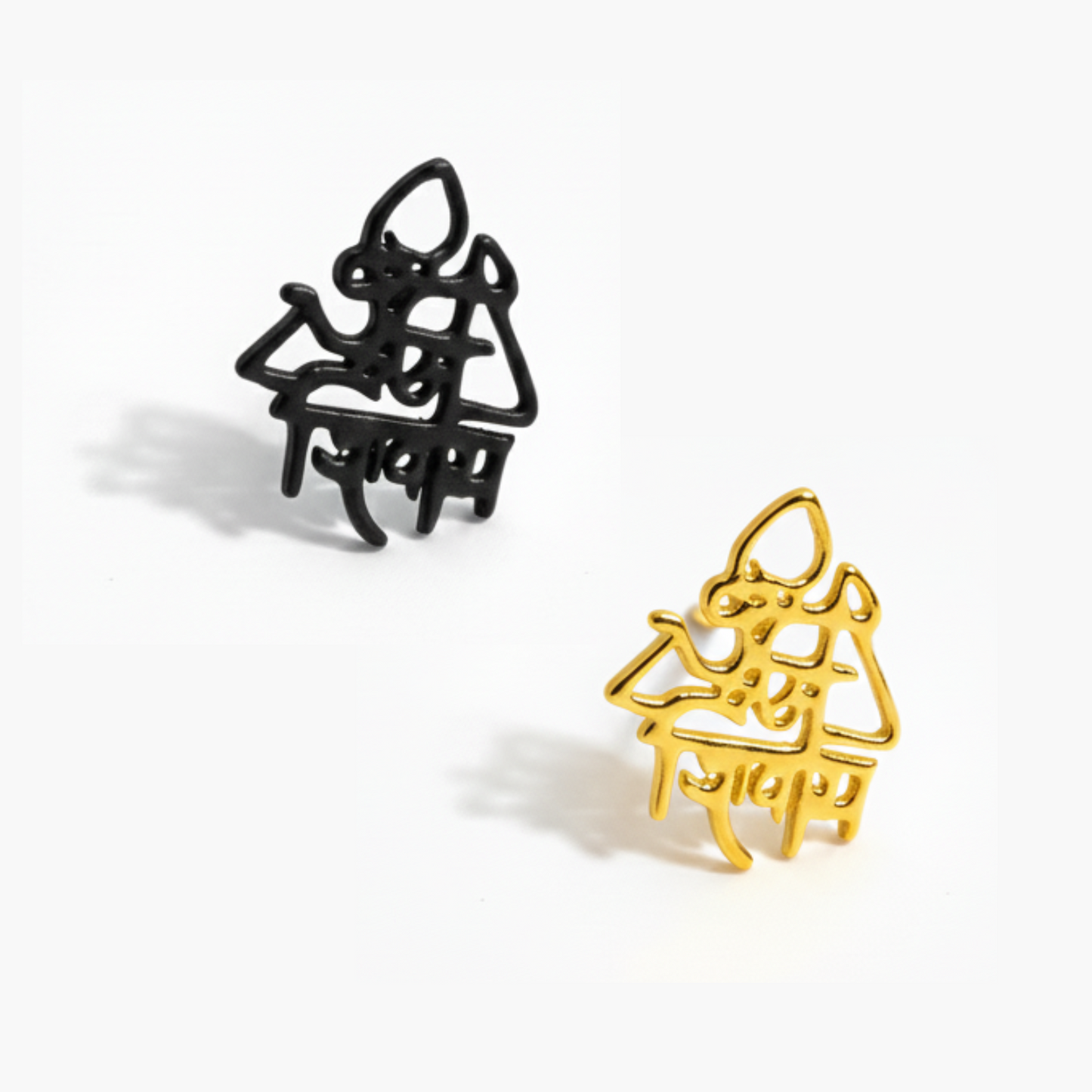 Black and gold cat-shaped hair clips on a white background