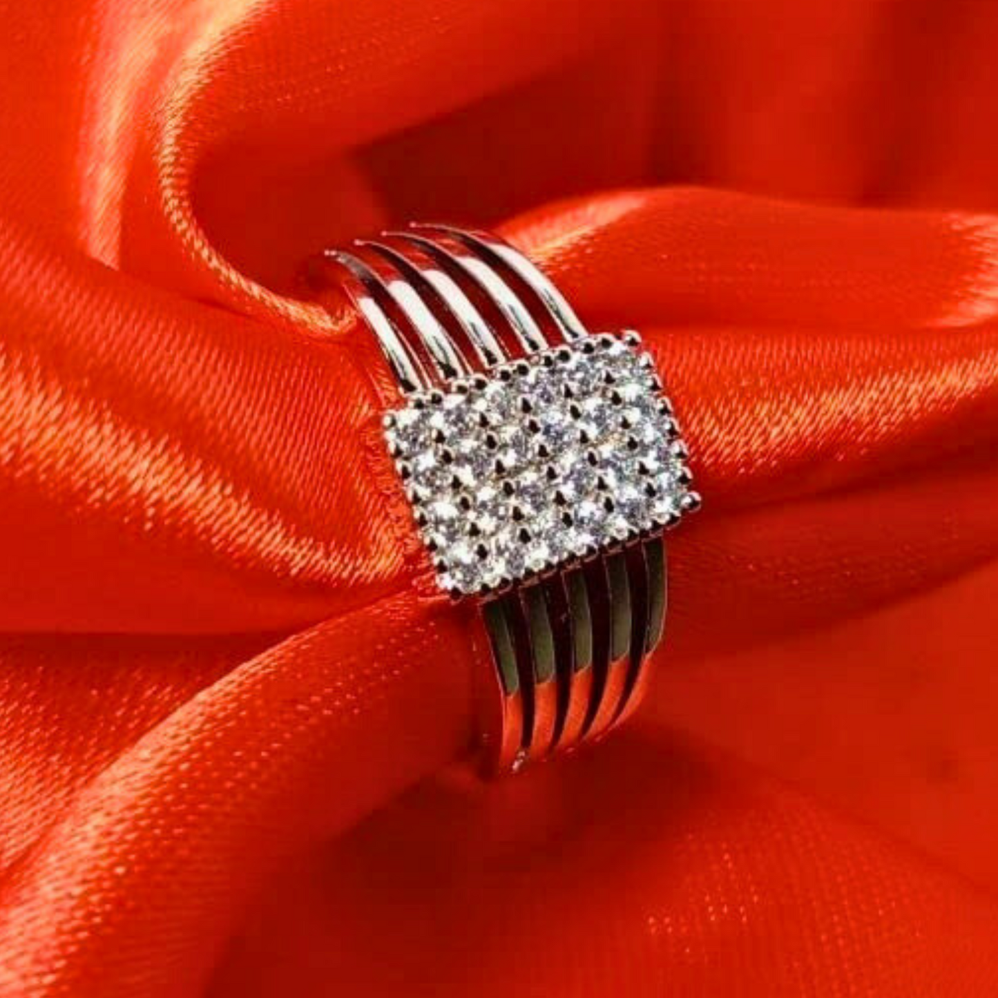 Silver ring with gemstones on a red satin background