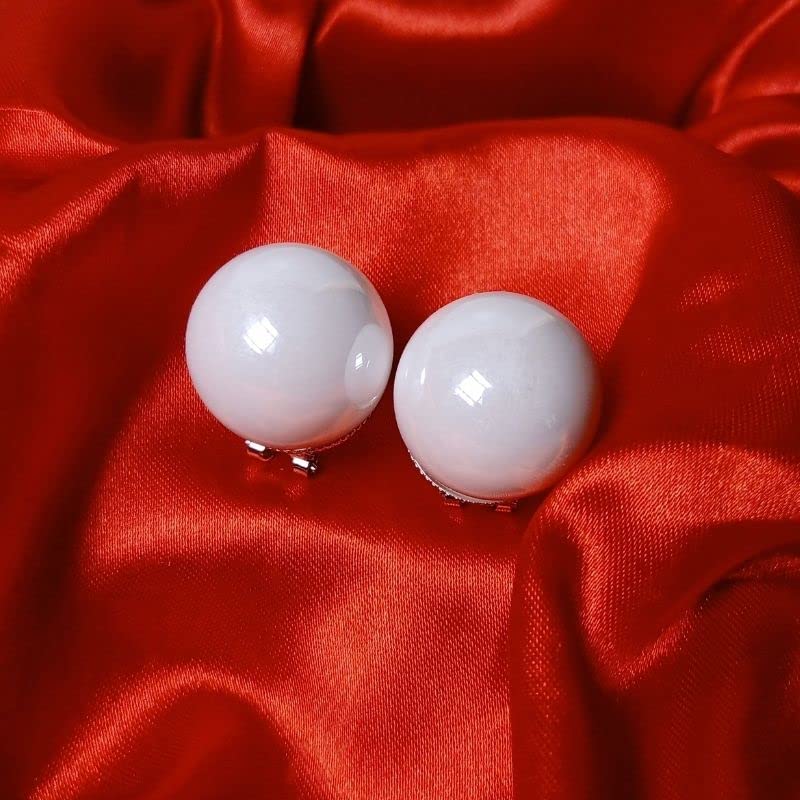 White spherical earrings on a red fabric background
