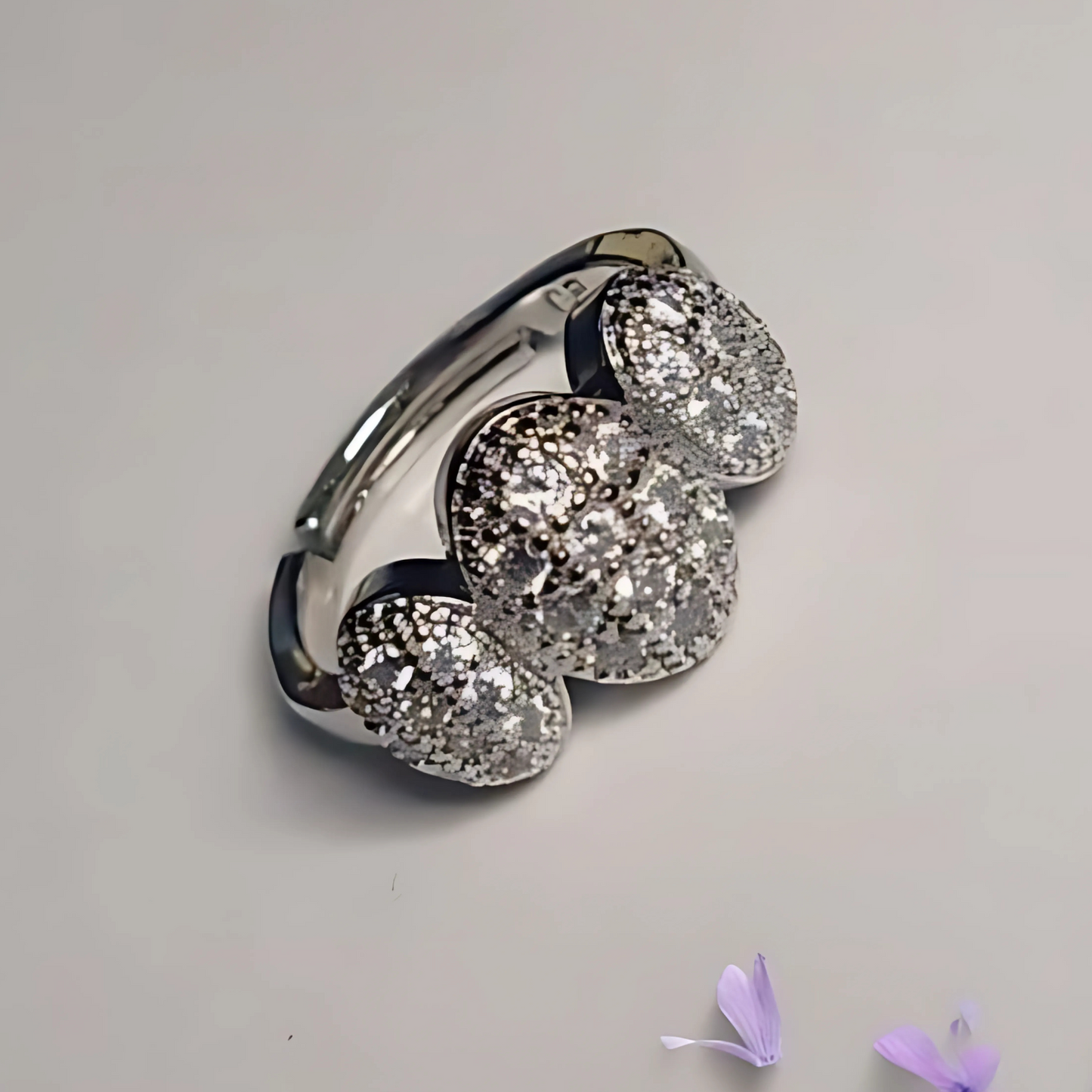 Silver ring with three large gemstones on a light gray background