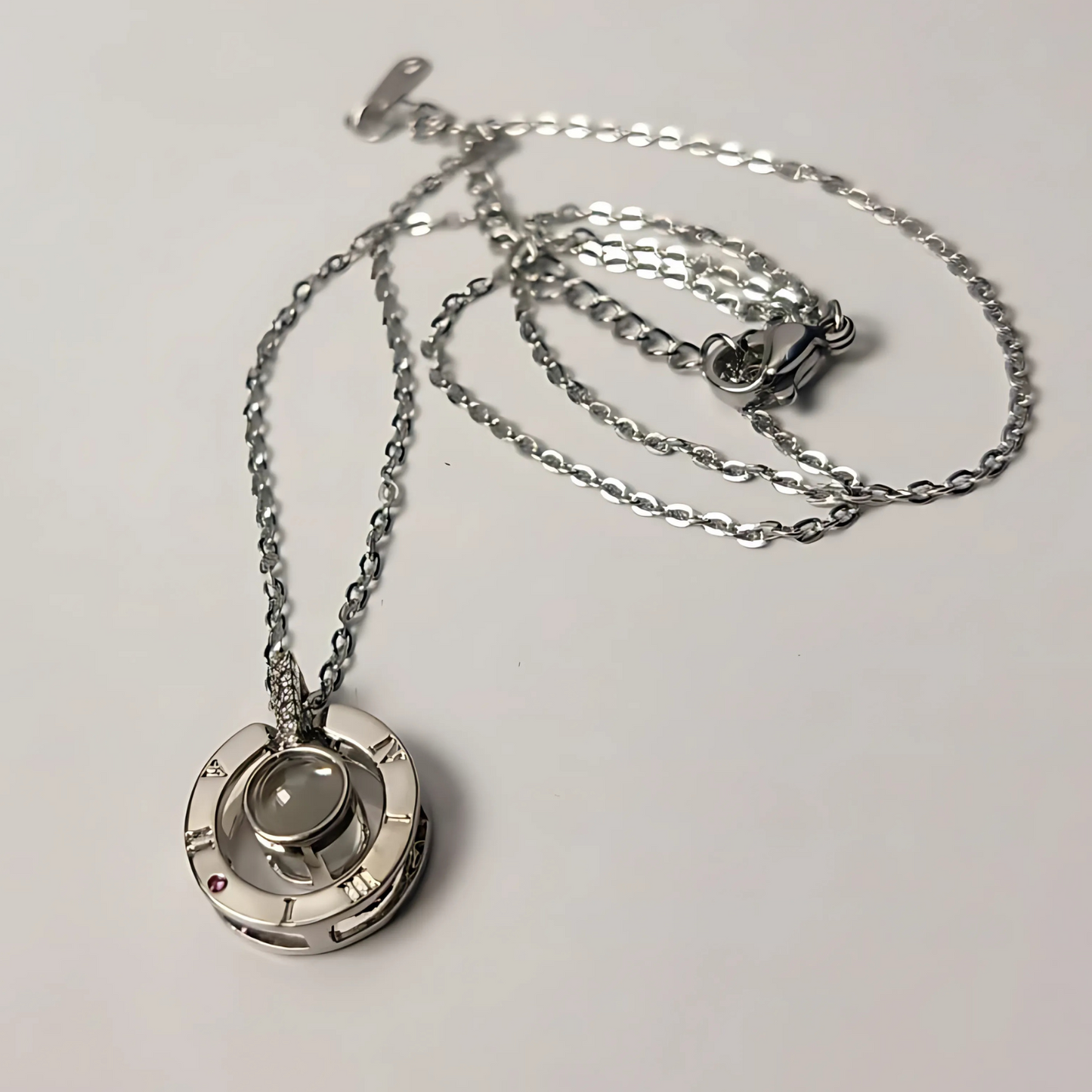 Silver necklace with a pendant on a light gray background