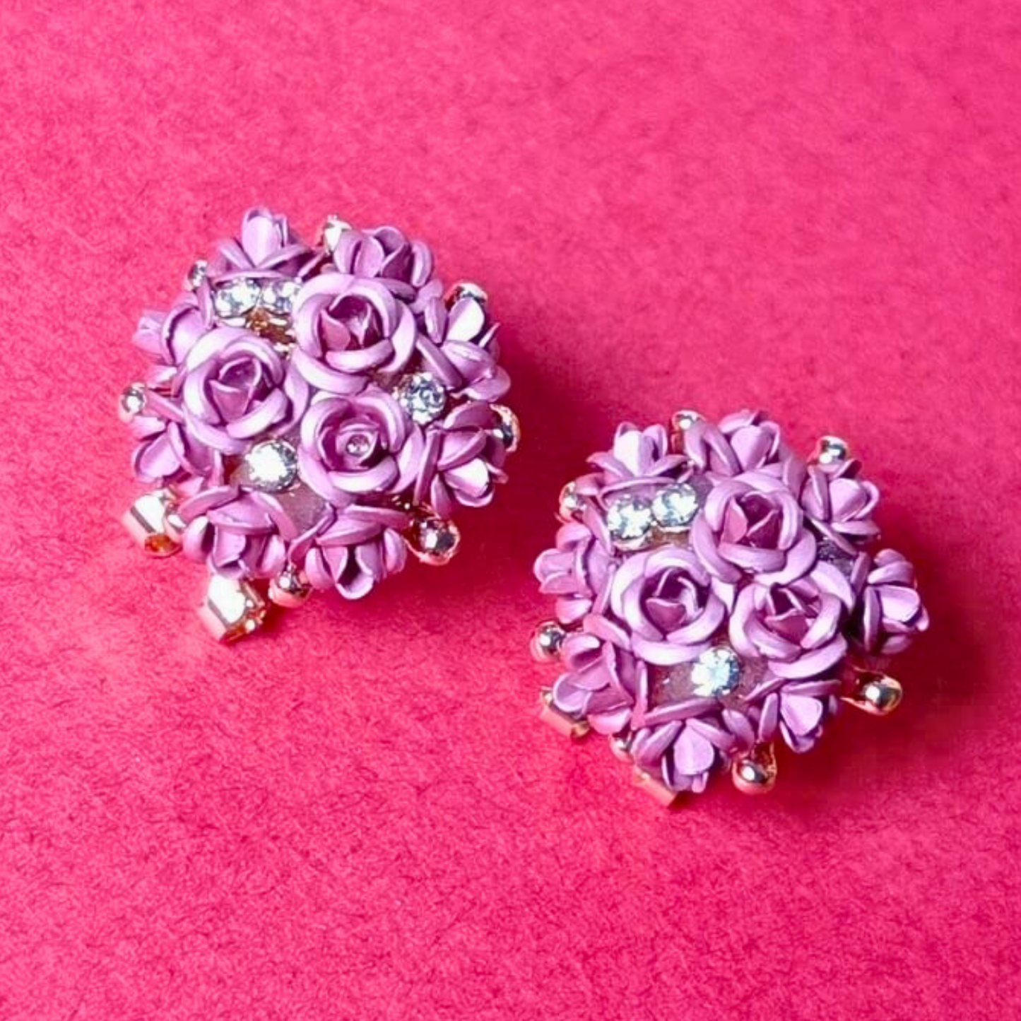 Pink floral earrings with rhinestones on a pink background