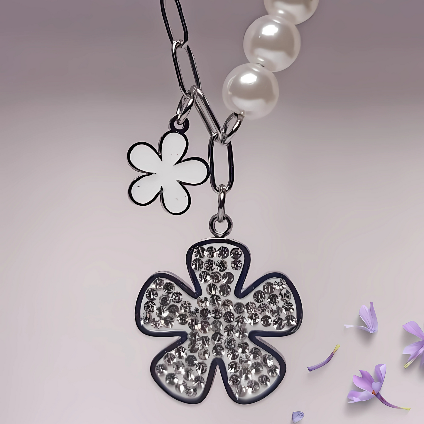 Necklace with a clover-shaped pendant and flower charm on a light background
