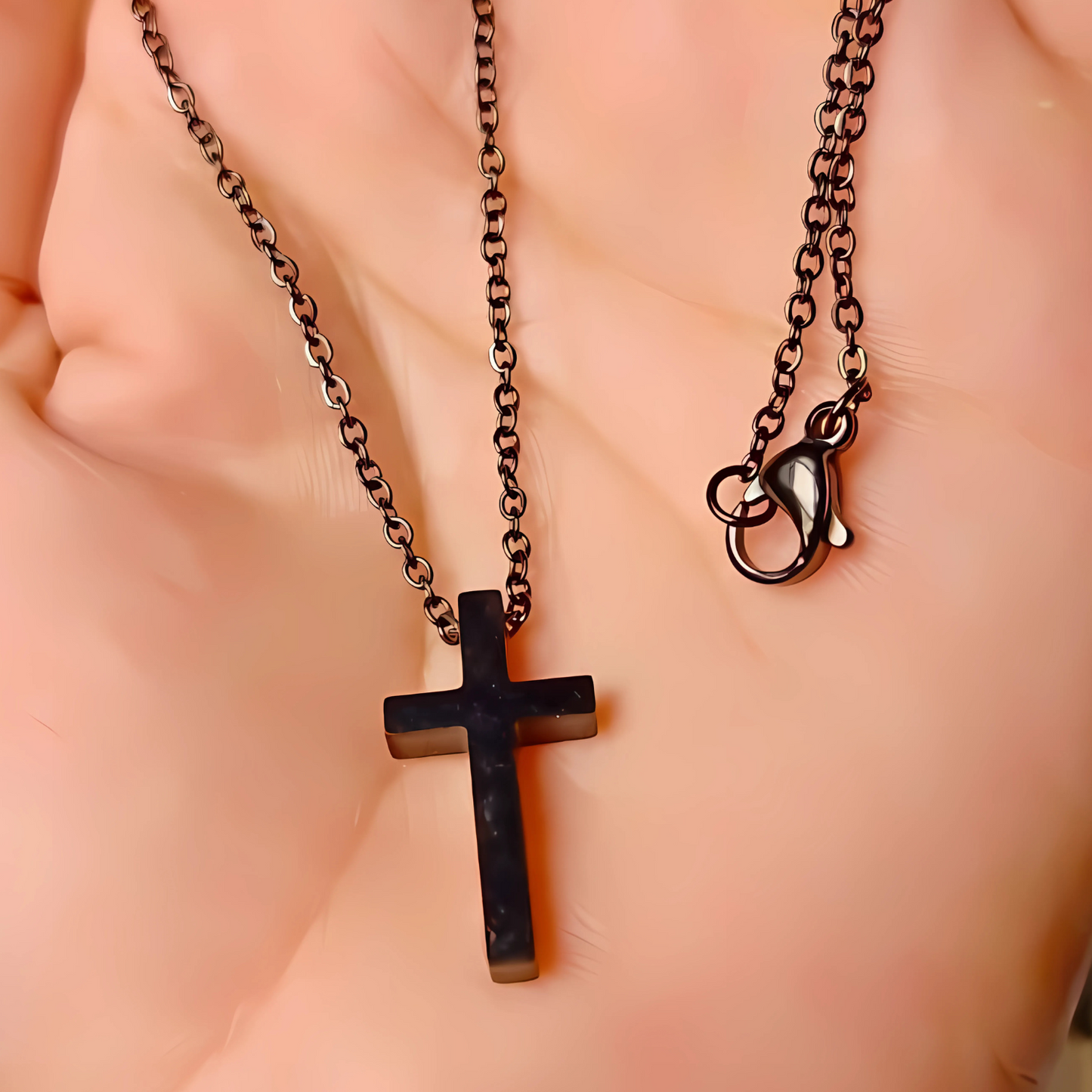 Black cross pendant necklace on a person's neck against a neutral background