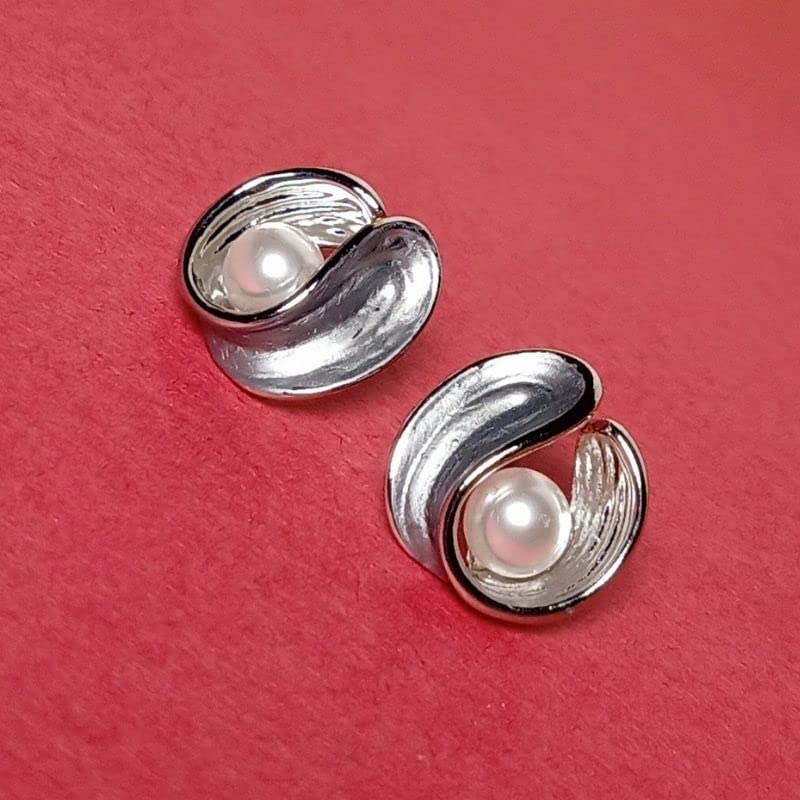 Silver earrings with pearls on a red background