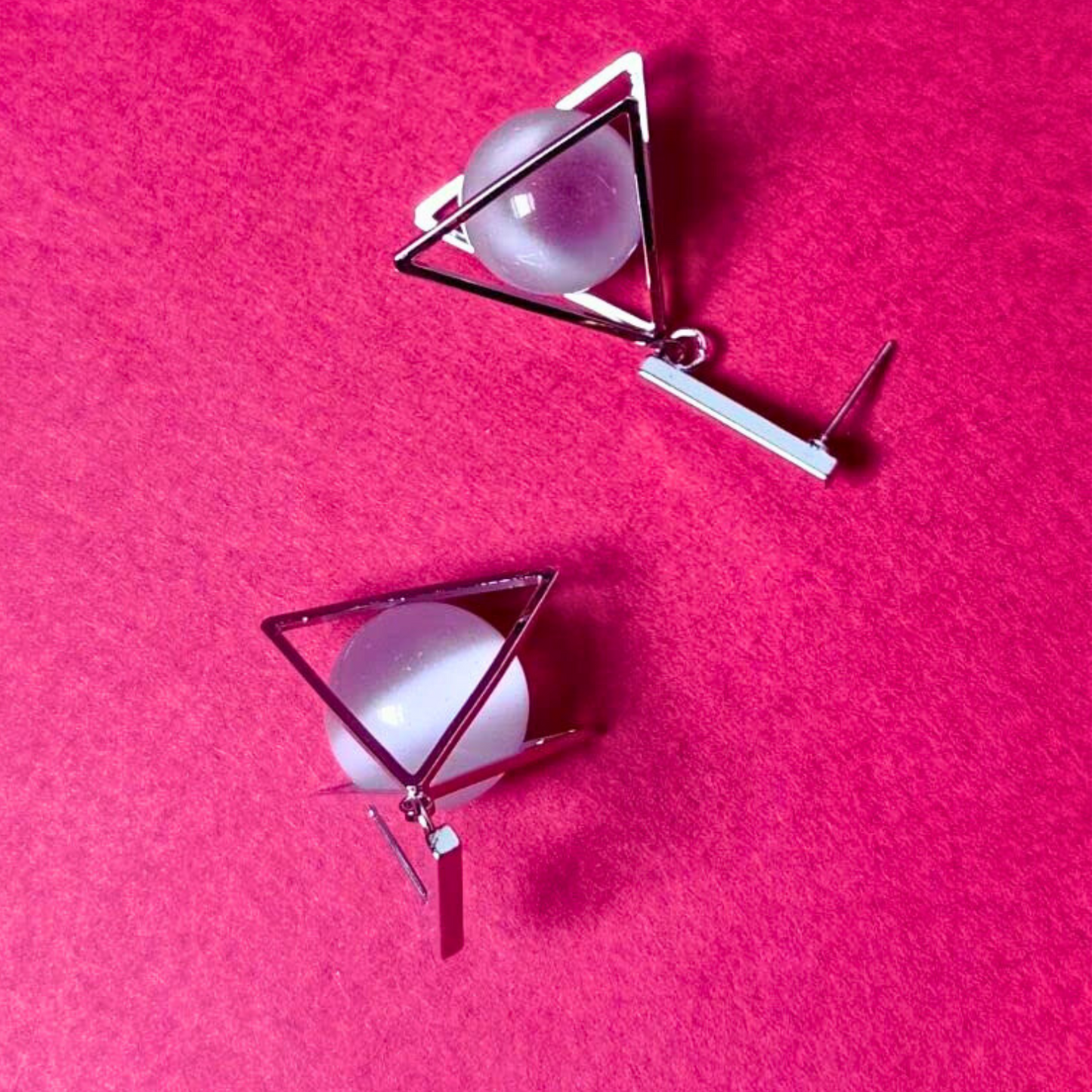 Earrings with geometric design on a pink background