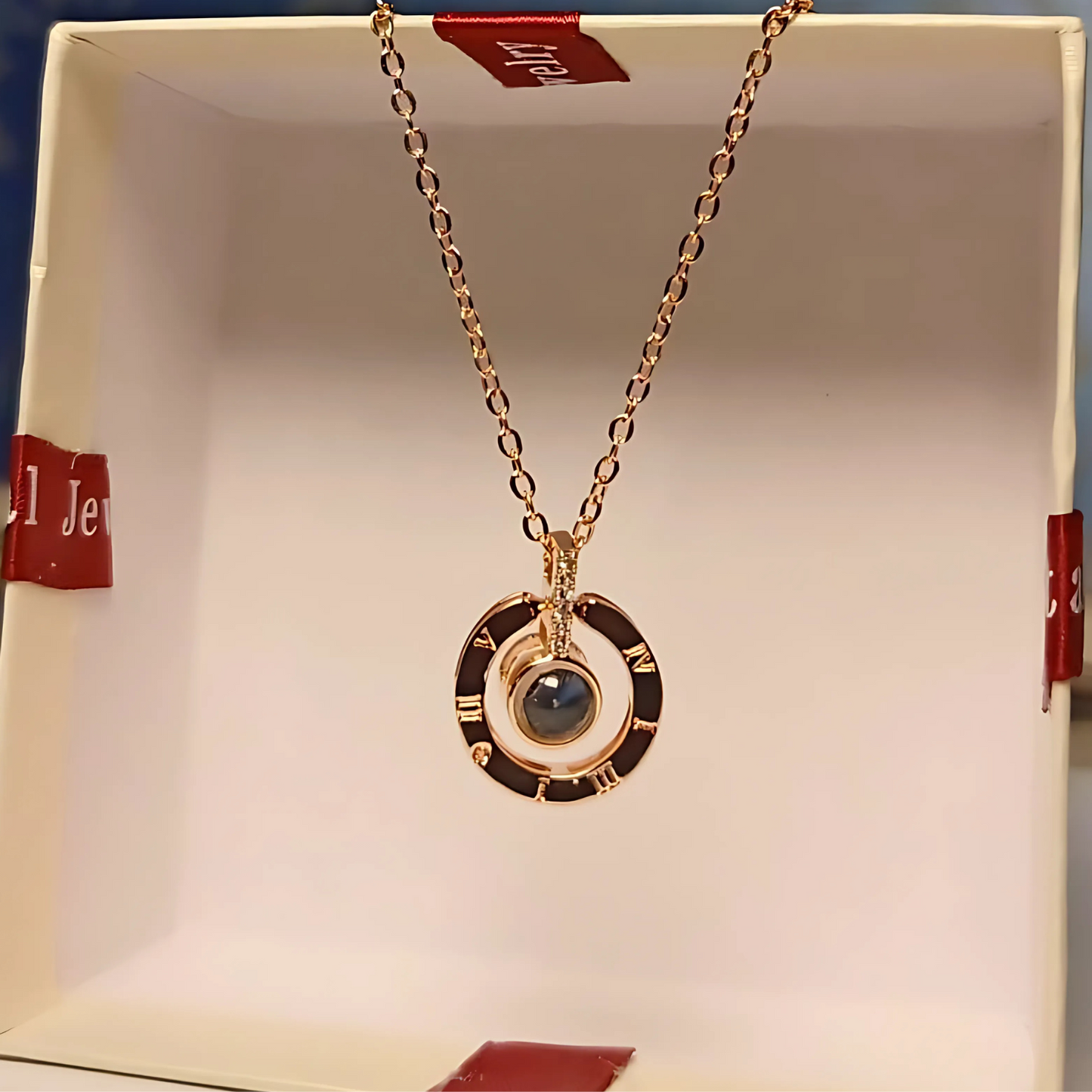 Gold necklace with a pendant on a branded box