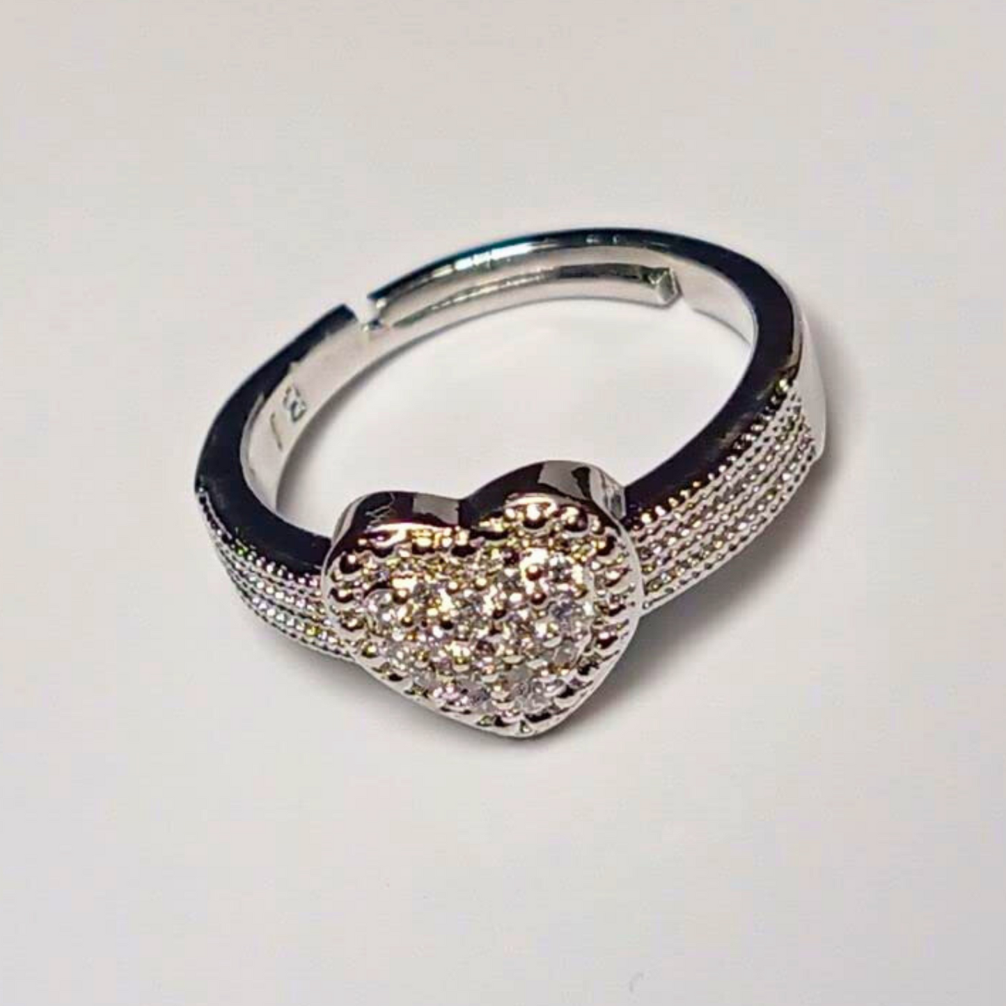 Silver hoop earring with a heart-shaped gemstone on a light gray background