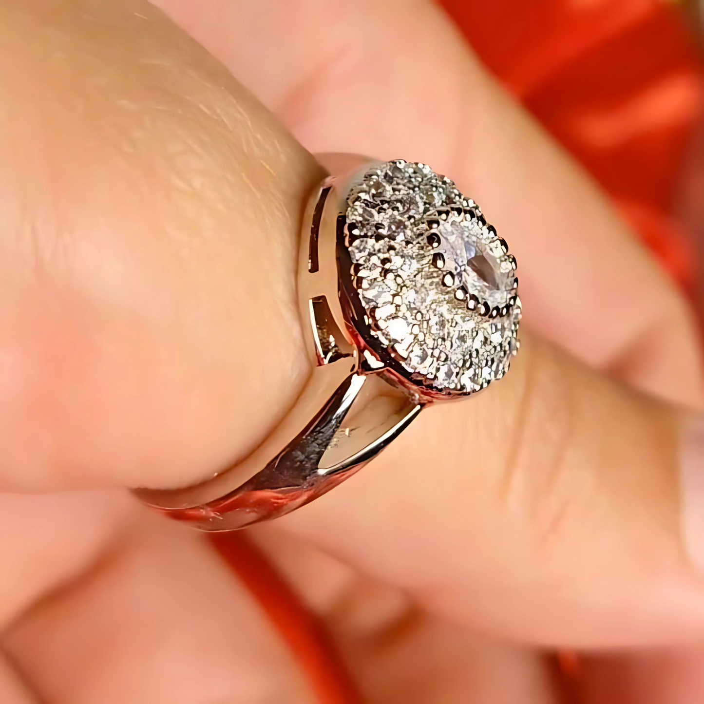 Close-up of a diamond ring on a finger with a blurred background