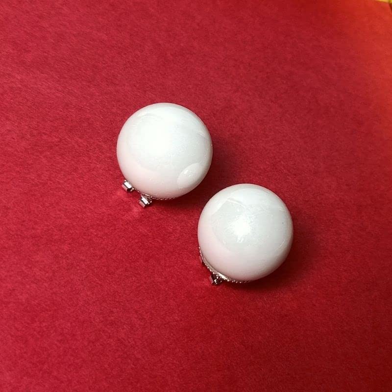 Pair of white round earrings on a red background