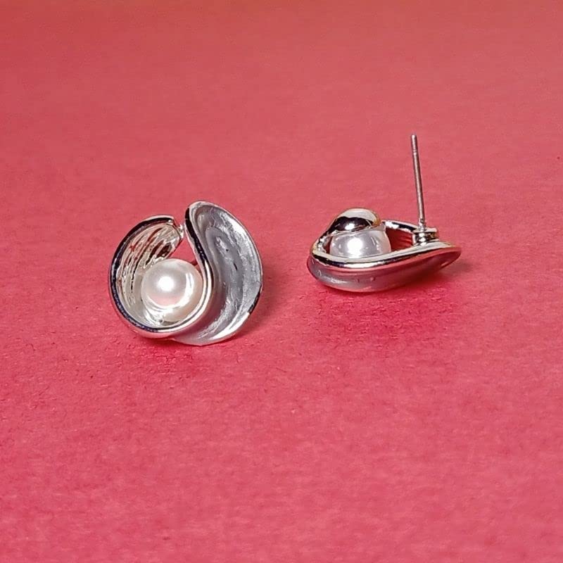 Silver earrings with a pearl on a pink background