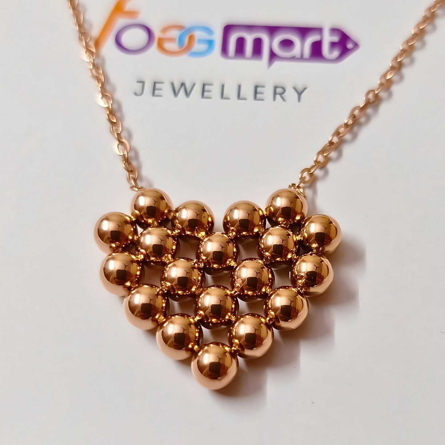 Rose gold necklace with a geometric design on a 'Foggmart Jewellery' card.
