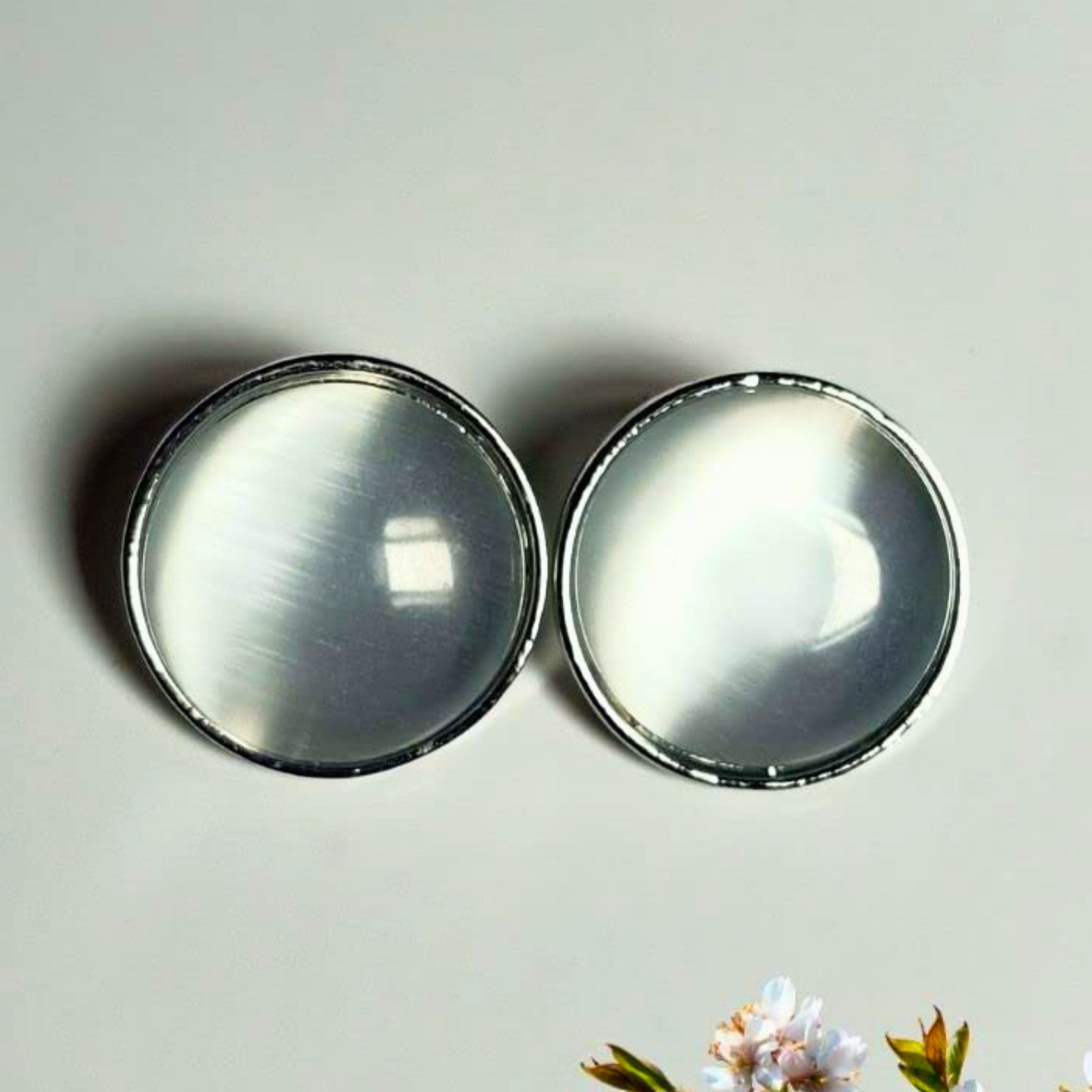 Two round metallic objects on a light gray background
