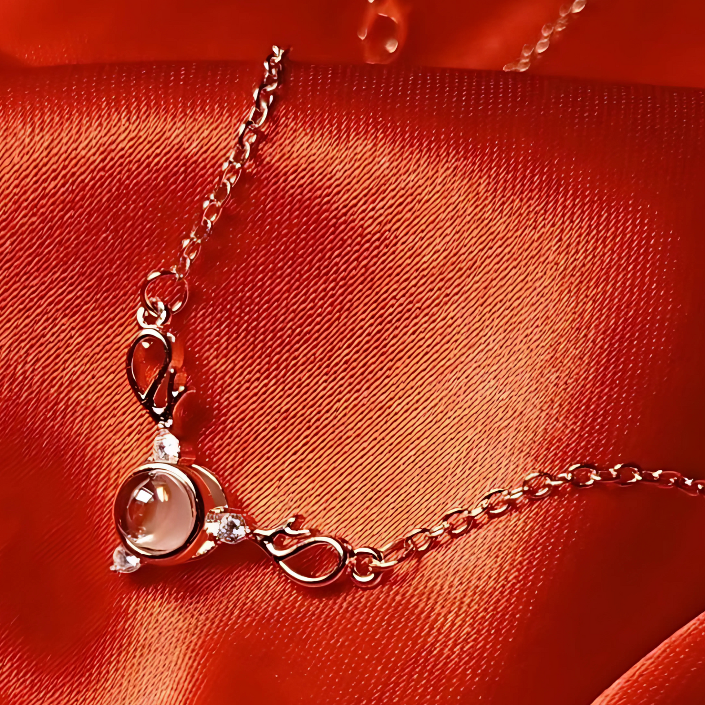 Delicate necklace with a pink gemstone on a red fabric background