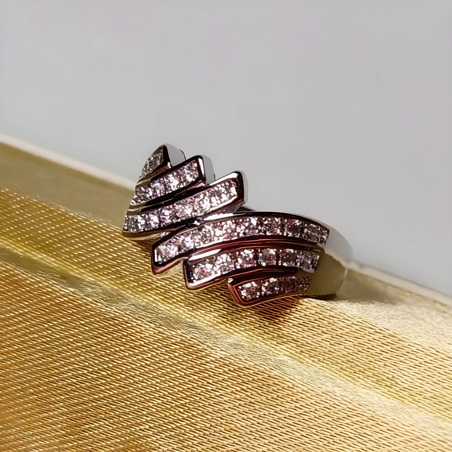 Silver ring with diamond accents on a textured beige surface