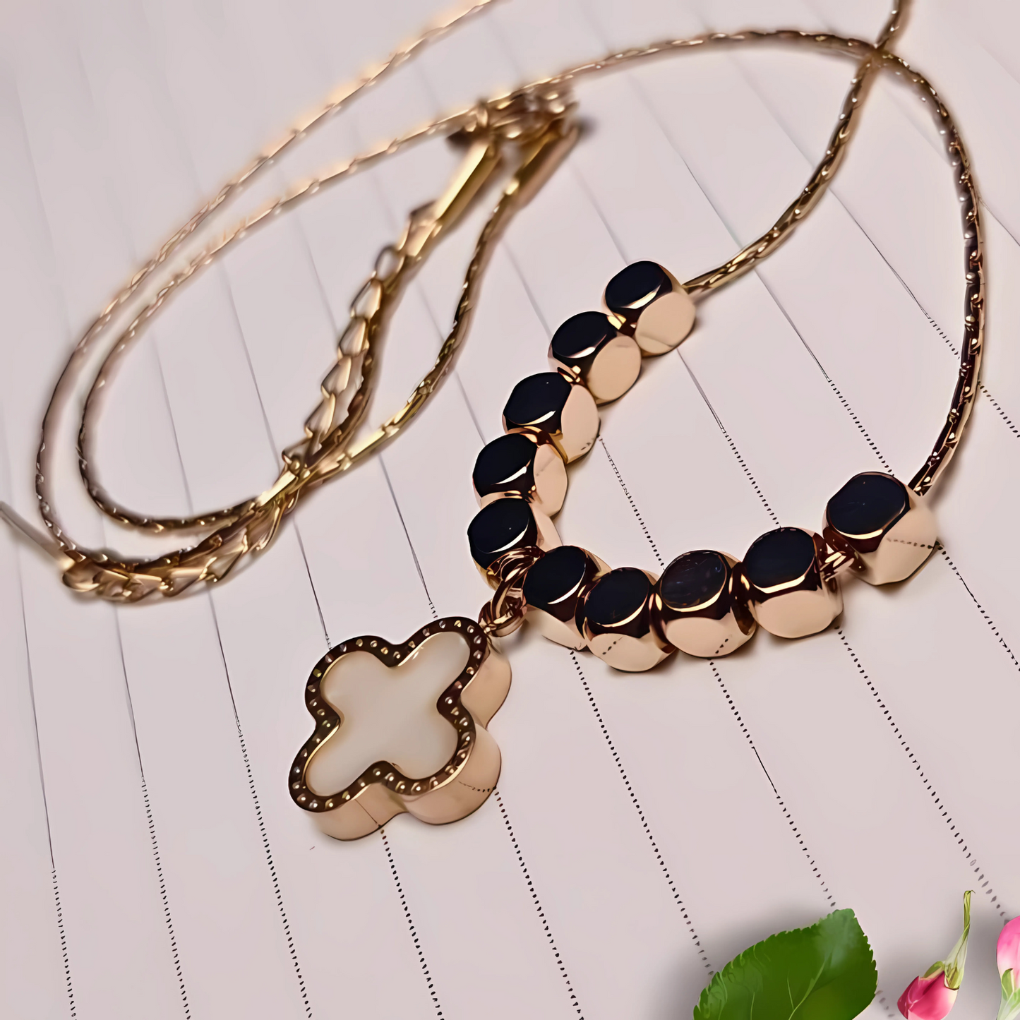 Gold necklace with a floral pendant on a light wooden surface