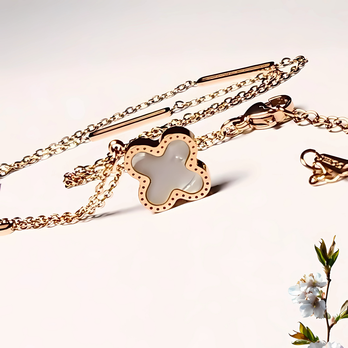 Gold necklace with a clover-shaped charm on a light background
