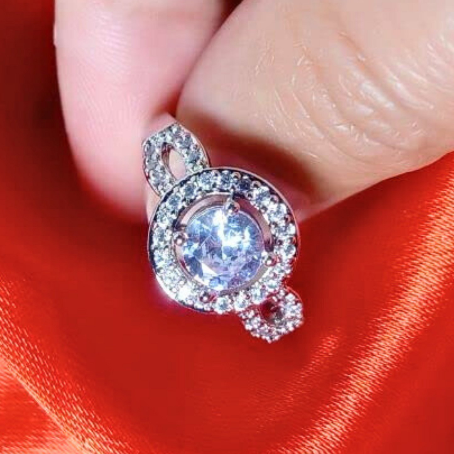 Close-up of a silver ring with a large gemstone on a red fabric background